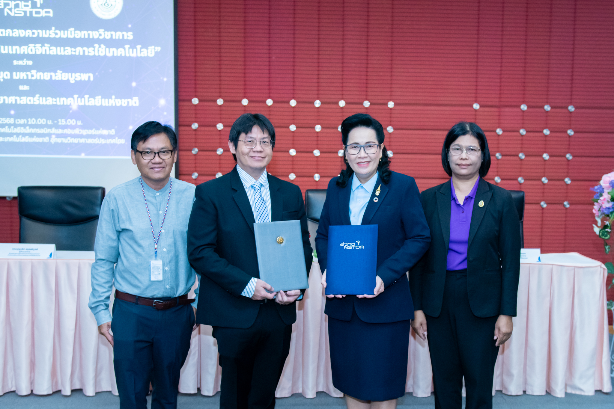 ภาพบรรยากาศ ผู้บริหารร่วมถ่ายรูป โดยมี ดร. จุฬารัตน์ ตันประเสริฐ รองผู้อำนวยการ สำนักงานพัฒนาวิทยาศาสตร์และเทคโนโลยีแห่งชาติ และ นายเหมรัศมิ์ วชิรหัตถพงศ์ ผู้อำนวยการสำนักหอสมุด มหาวิทยาลัยบูรพา อยู่ตรงกลาง พร้อมด้วย นายบุญเลิศ อรุณพิบูลย์ ผู้อำนวยการฝ่ายบริการความรู้ทางวิทยาศาสตร์และเทคโนโลยี และ นางวัชรีย์พร คุณสนอง รองผู้อำนวยการฝ่ายวิชาการ สำนักหอสมุด มหาวิทยาลัยบูรพา
