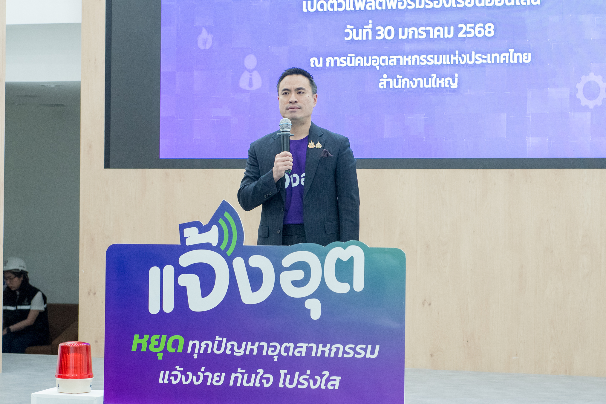 ภายถ่ายรวม โดยมีนายเอกนัฏ ถือไมค์ หลังป้าย “แจ้งอุต" หยุดทุกปัญหาอุตสาหกรรมแจ้งง่าย ทันใจ โปร่งใส