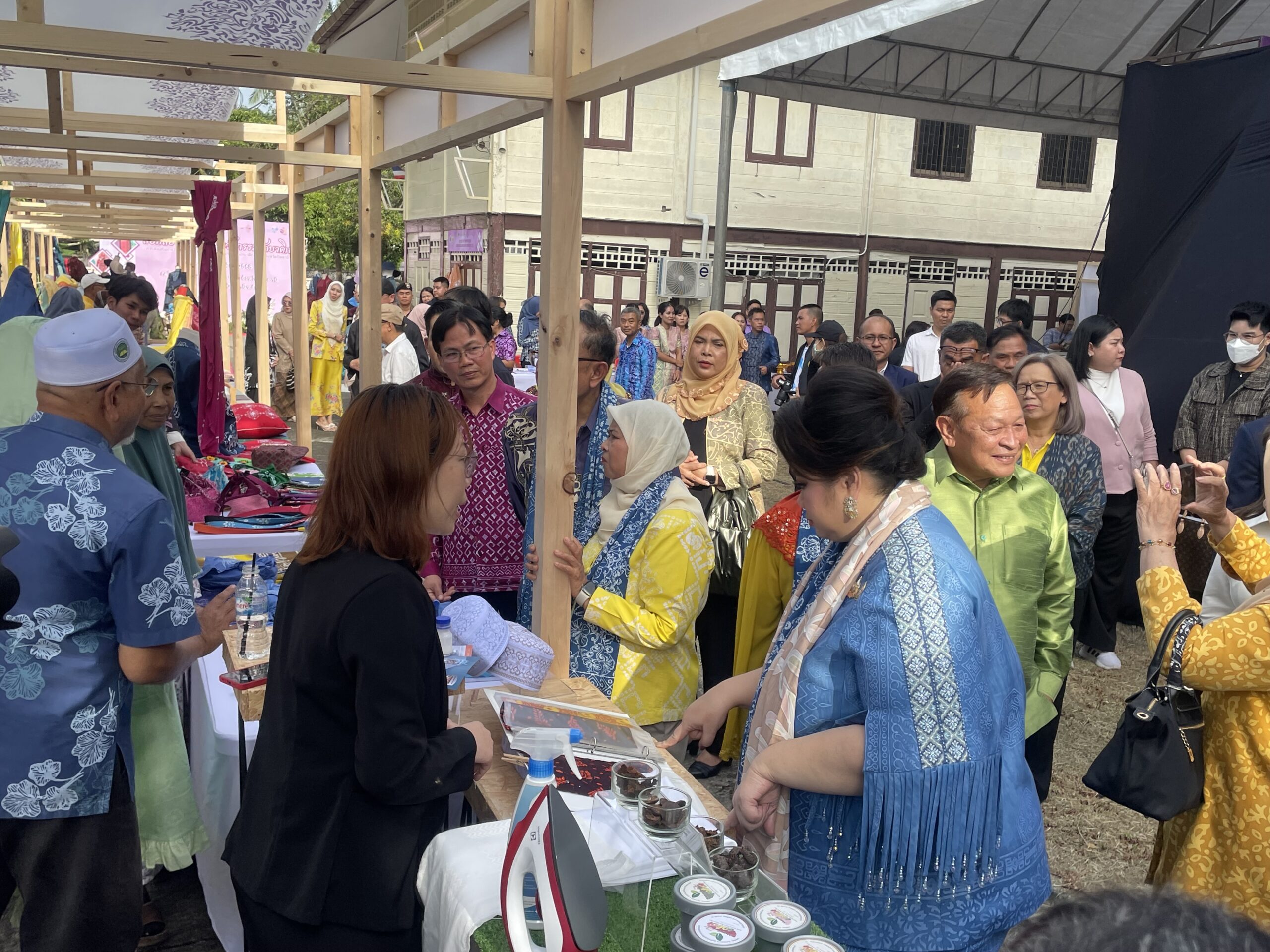 นางสาวศุภมาส อิศรภักดี รัฐมนตรีว่าการกระทรวงการอุดมศึกษา วิทยาศาสตร์ วิจัยและนวัตกรรม (อว.) เดินดูงานสินค้าจากนวัตกรรมผ้าบาติก โดยมีผู้สนใจเข้าชมนวัตกรรมผ้าบาติกล้อมรอบ