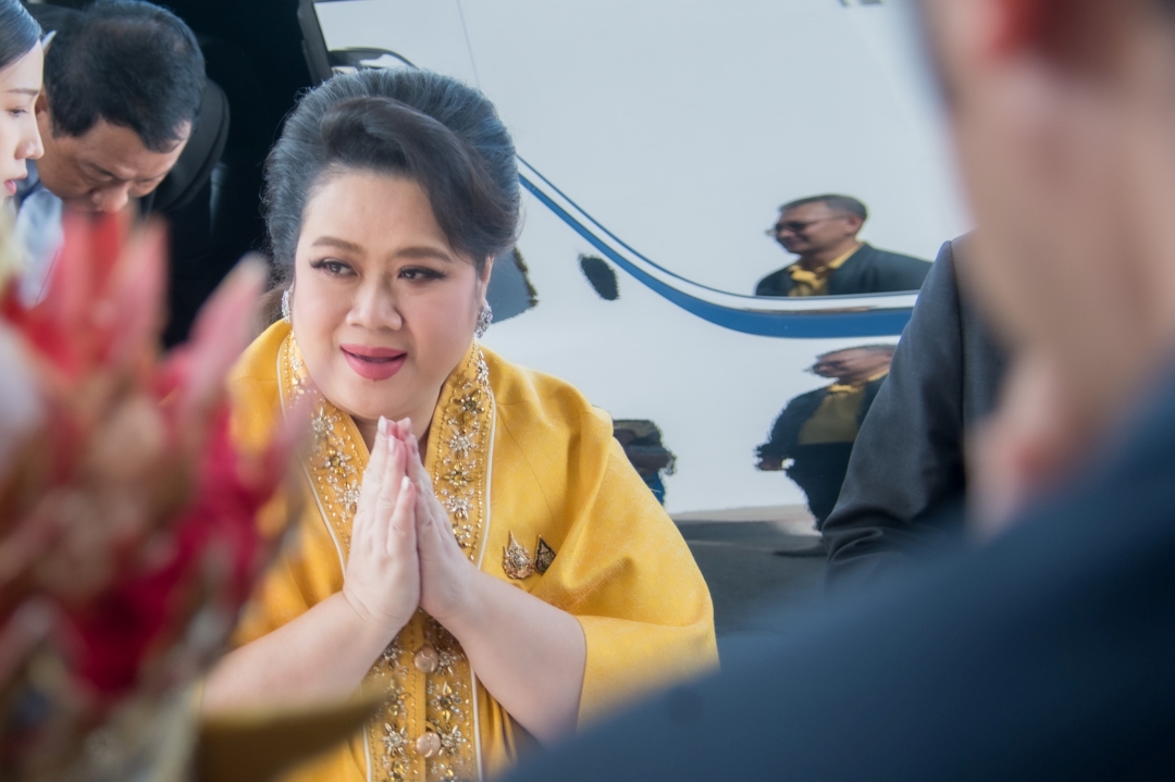 ภาพรัฐมนตรีศุภมาส อิศรภักดี ในชุดสีเหลืองทอง กำลังยกมือไหว้สวัสดีผู้เข้าร่วมงาน