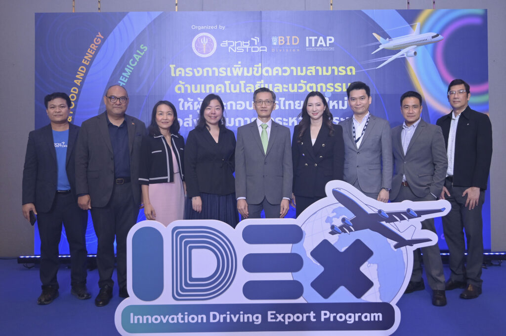 ภาพผู้บริหาร 9 ท่าน ถ่ายหน้าฉากหลังที่เป็นชื่อโครงการ และมีป้ายที่เป็นโลโก้วางอยู่ด้านหน้า โลโก้ IDEx และรูปเครื่องบินบินขึ้น บ่งบอกถึงการส่งออก