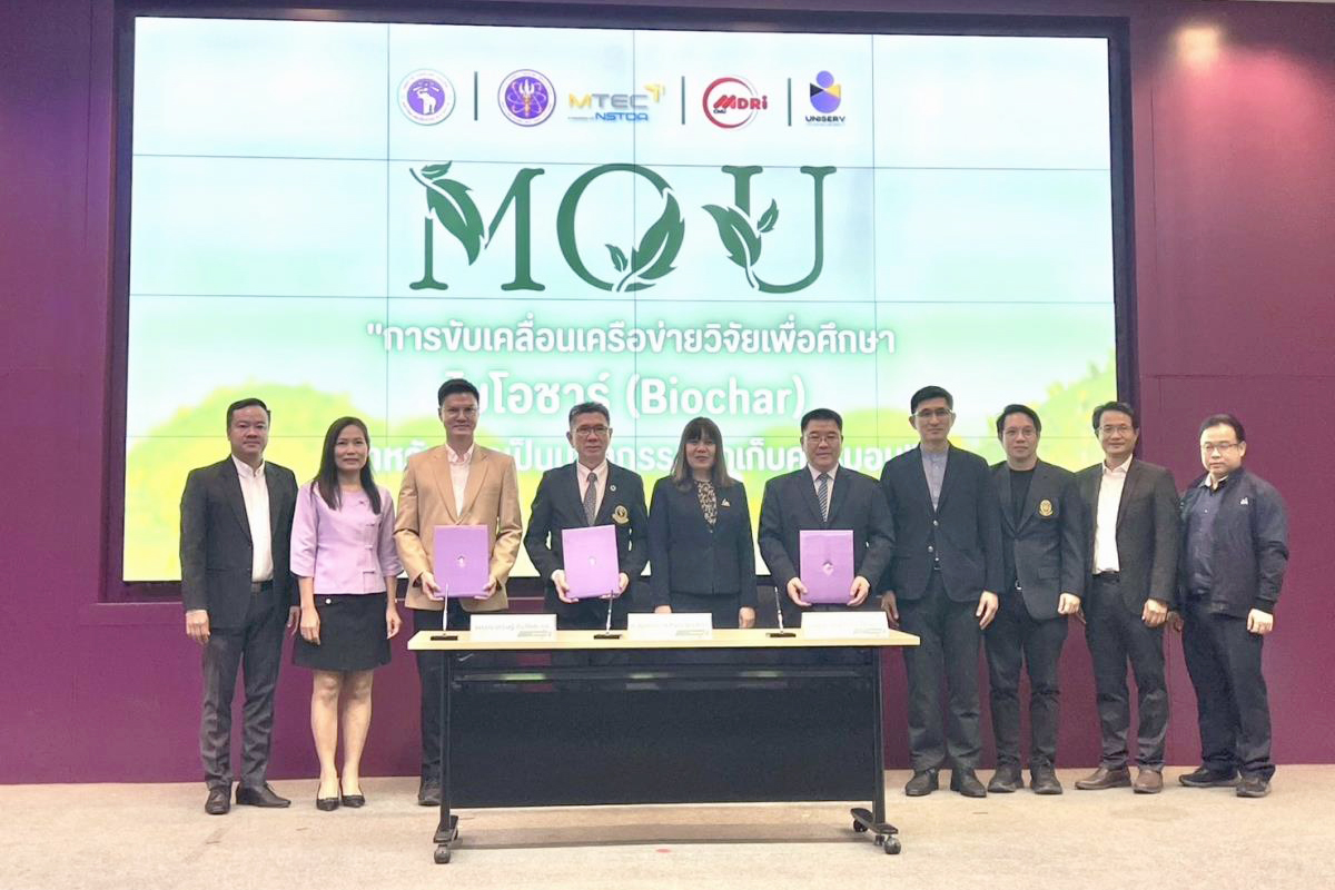 ภาพหมู่ผู้บริหารและทีมงานจากศูนย์เทคโนโลยีโลหะและวัสดุแห่งชาติ (เอ็มเทค)และสำนักบริการวิชาการ มหาวิทยาลัยเชียงใหม่ จำนวน 10 ท่าน ถ่ายรูปร่วมกันบนเวที โชว์เอกสารความร่วมมือ ฉากหลังเป็นข้อความ MOU และชื่องาน