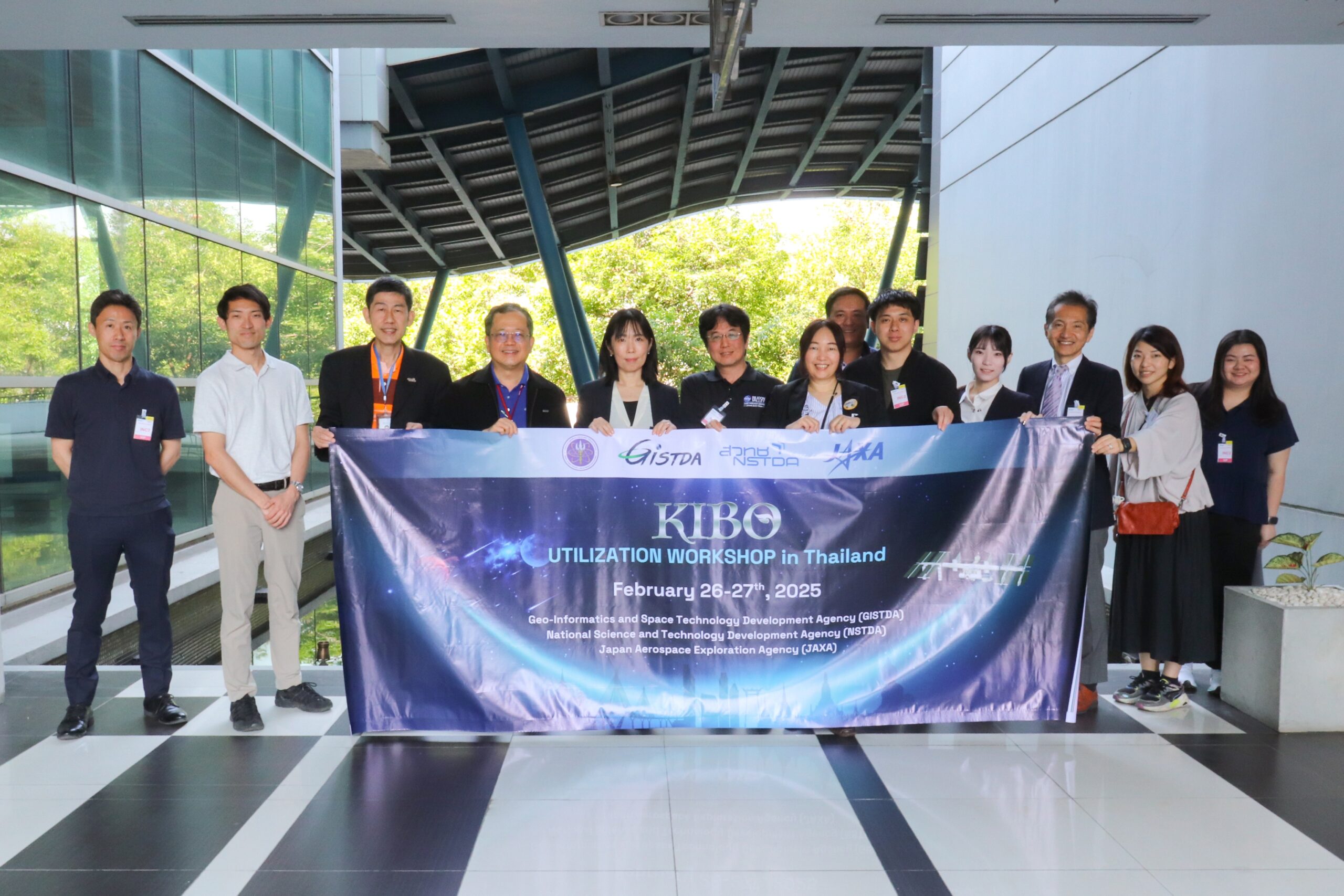 ภาพคณะ JAXA และ สวทช. ถ่ายรูปร่วมกันและโชว์ป้ายงาน KIBO