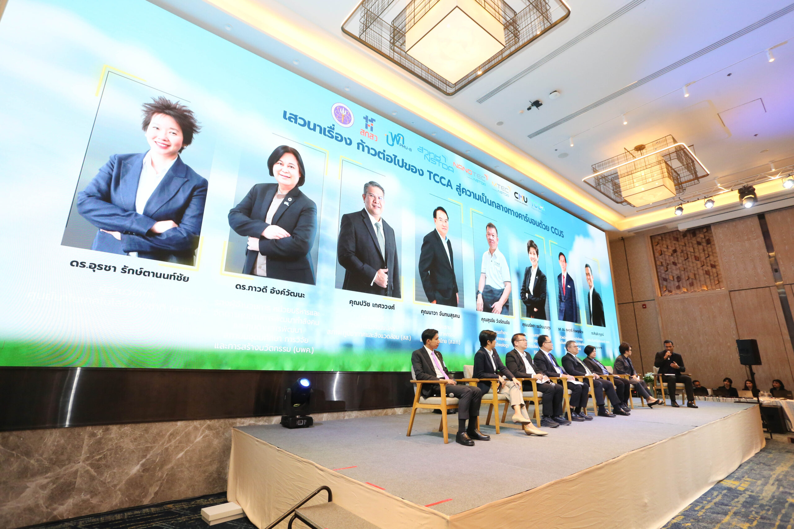 ภาพเวทีเสวนางาน Thailand CCUS Alliance (TCCA) ผู้ร่วมเสวนานั่งเรียงกันบนเวที ข้างหลังเป็นจอ LED ขนาดใหญ่แสดงหัวข้อเสวนา ‘ก้าวต่อไปของ TCCA สู่ความเป็นกลางทางคาร์บอนด้วย CCUS’ พร้อมภาพและรายชื่อของวิทยากร