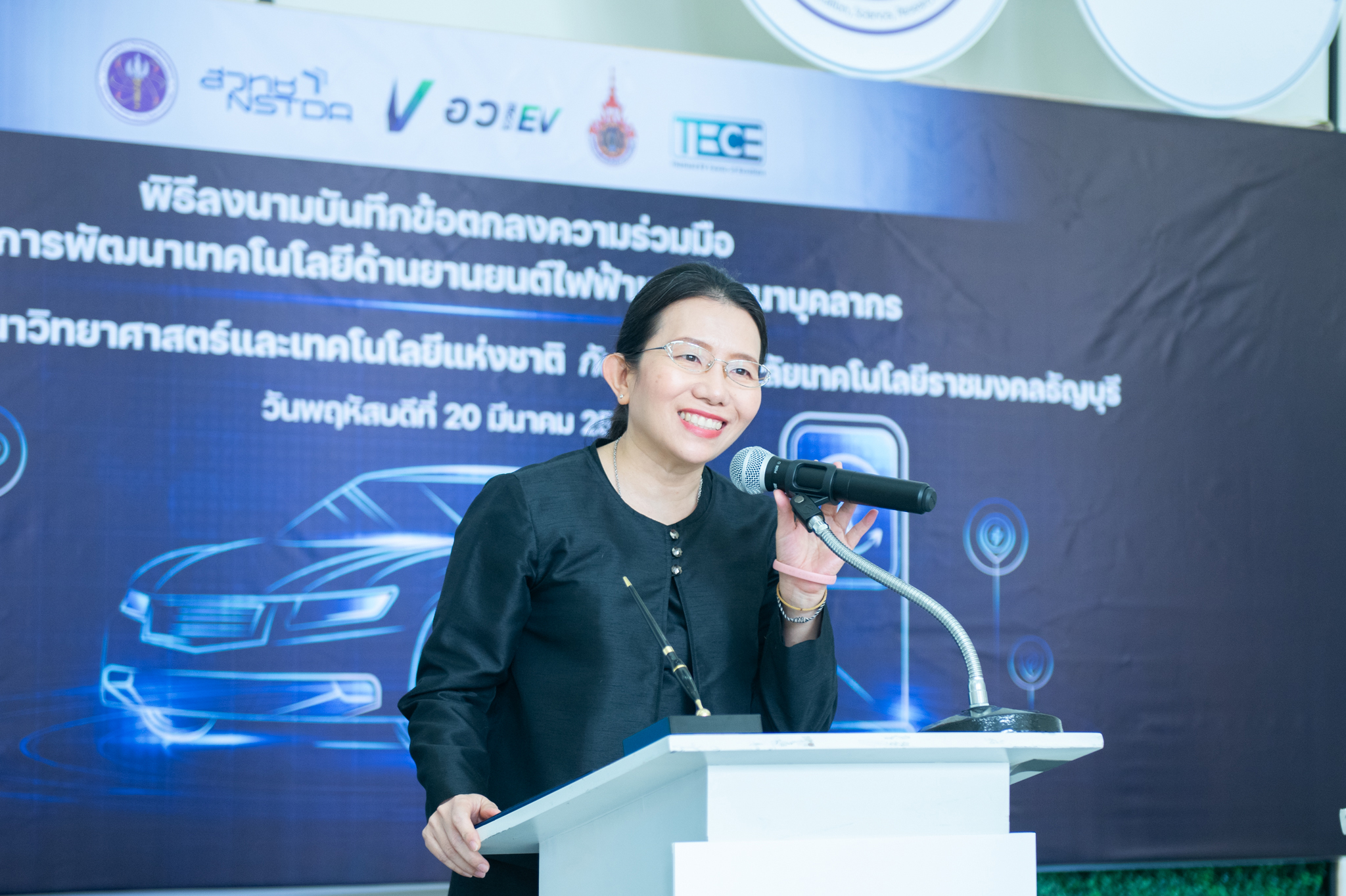 ภาพ ดร.สุมิตรา จรสโรจน์กุล ผู้อำนวยการเอ็นเทค สวทช.  ยืนกล่าว ตรงโพเดียม