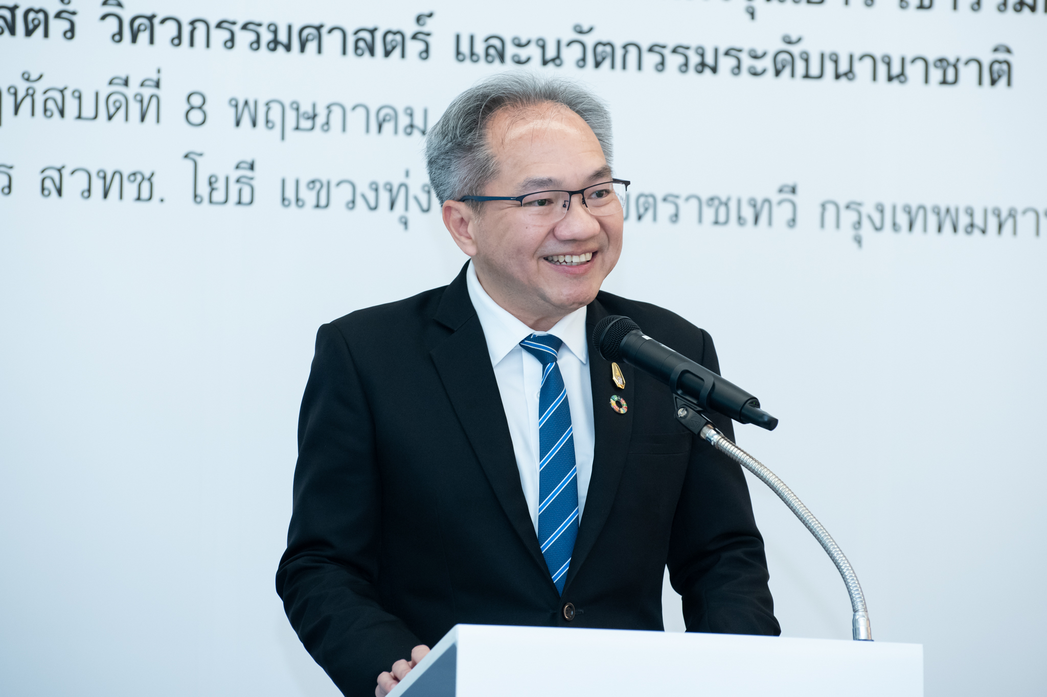 ภาพ ศาสตราจารย์ ดร.ชูกิจ ลิมปิจำนงค์ ผู้อำนวยการ สวทช. กล่าวว่า  ภารกิจหลักของ สวทช. ตรงโพเดียมสีขาว บนเวที