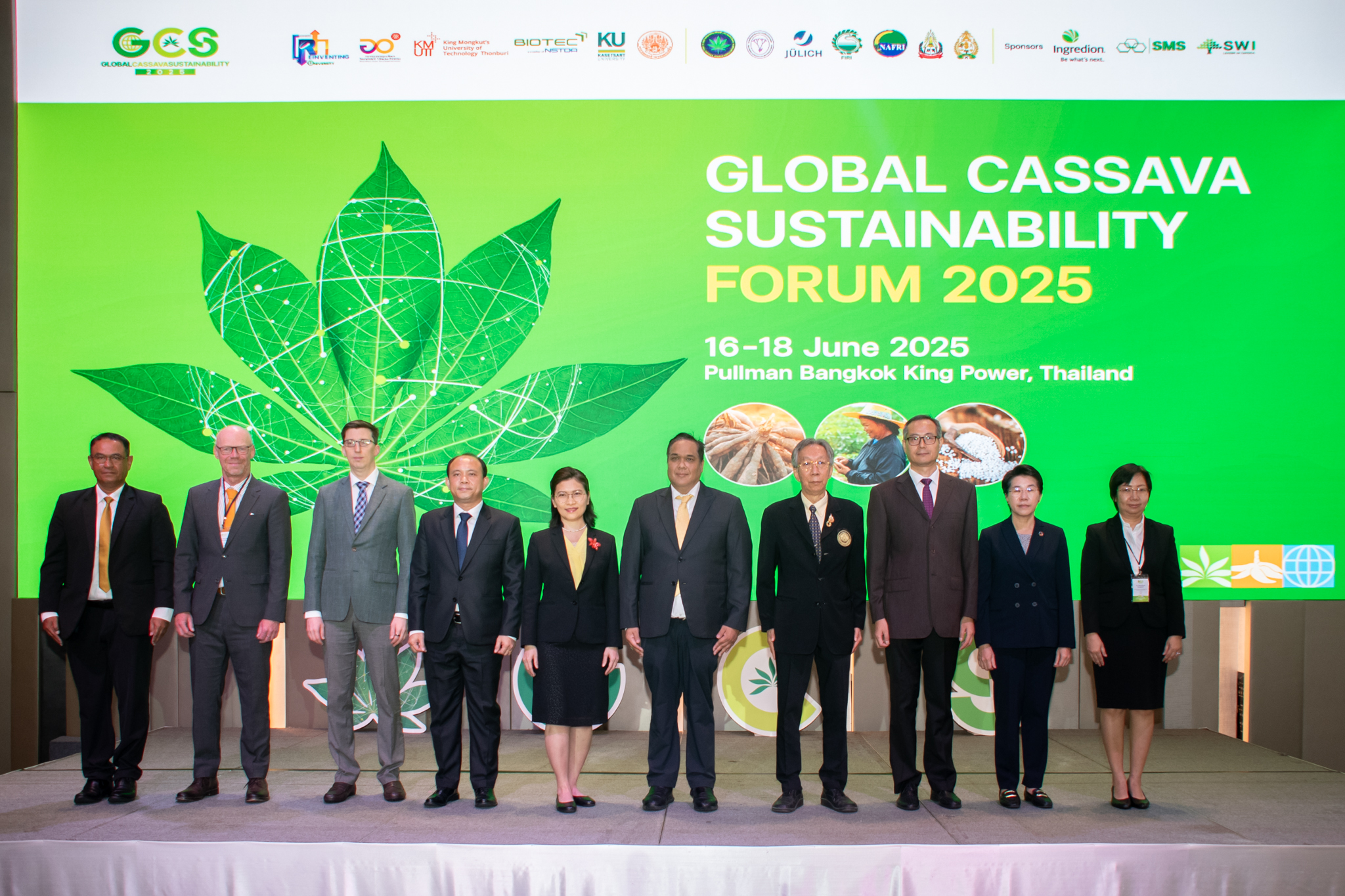 ภาพหมู่ ผู้บริหาร ยืนหน้า Blackdrop งาน Global Cassava Sustainability Forum 2025 ตรีมสีเขียวมีใบมันสำปะหลัง