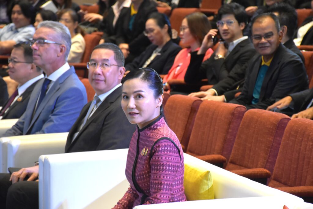 ภาพครึ่งตัวของ ศ.ดร.นฤมล ภิญโญสินวัฒน์ รมต.กระทรวงเกษตรและสหกรณ์ ซึ่งหันมามองกล้องนั่งตรงโซฟาด้านหน้าเวที