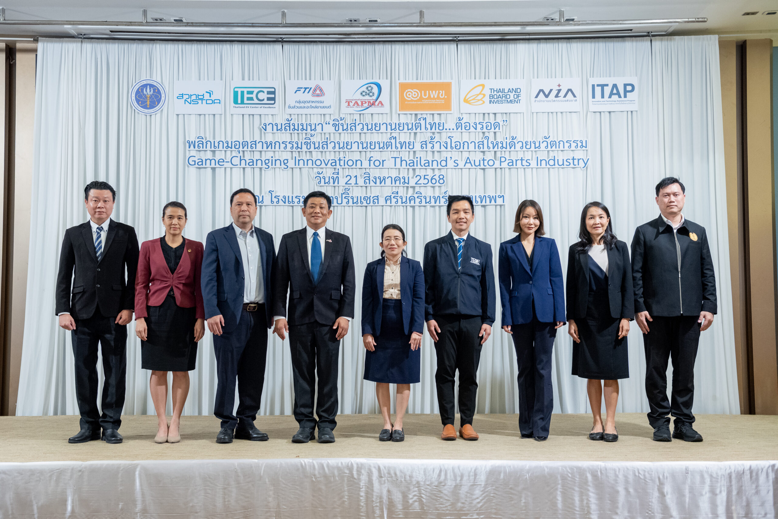 ภาพหมู่ ผู้บริหาร สวทช. TECE สภาอุตสาหกรรมแห่งประเทศไทย สถาบันยานยนต์ อยู่บนเวที สวมชุดสูท พร้อมด้วยท่าตรง ส่วนด้านหลัง เป็นผ้าม่านสีขาวที่มีโลโก้และชื่องาน