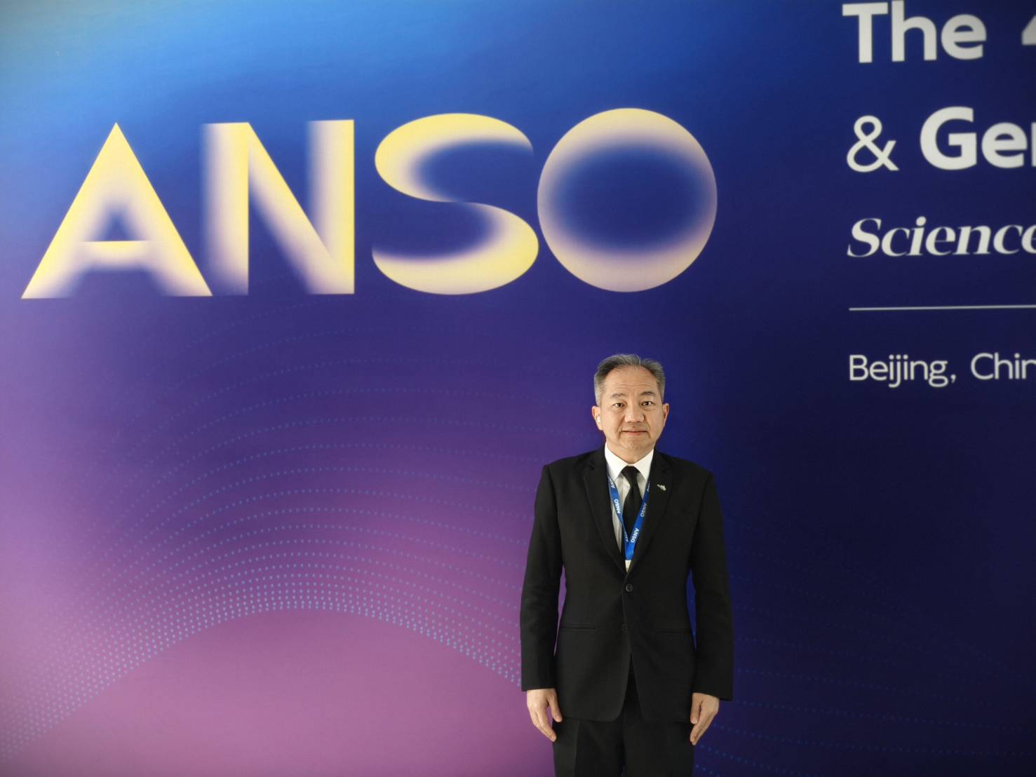 ภาพ ศาสตราจารย์ ดร.ชูกิจ ยืนหน้า Backdrop งาน ANSO ธีมสีน้ำเงิน