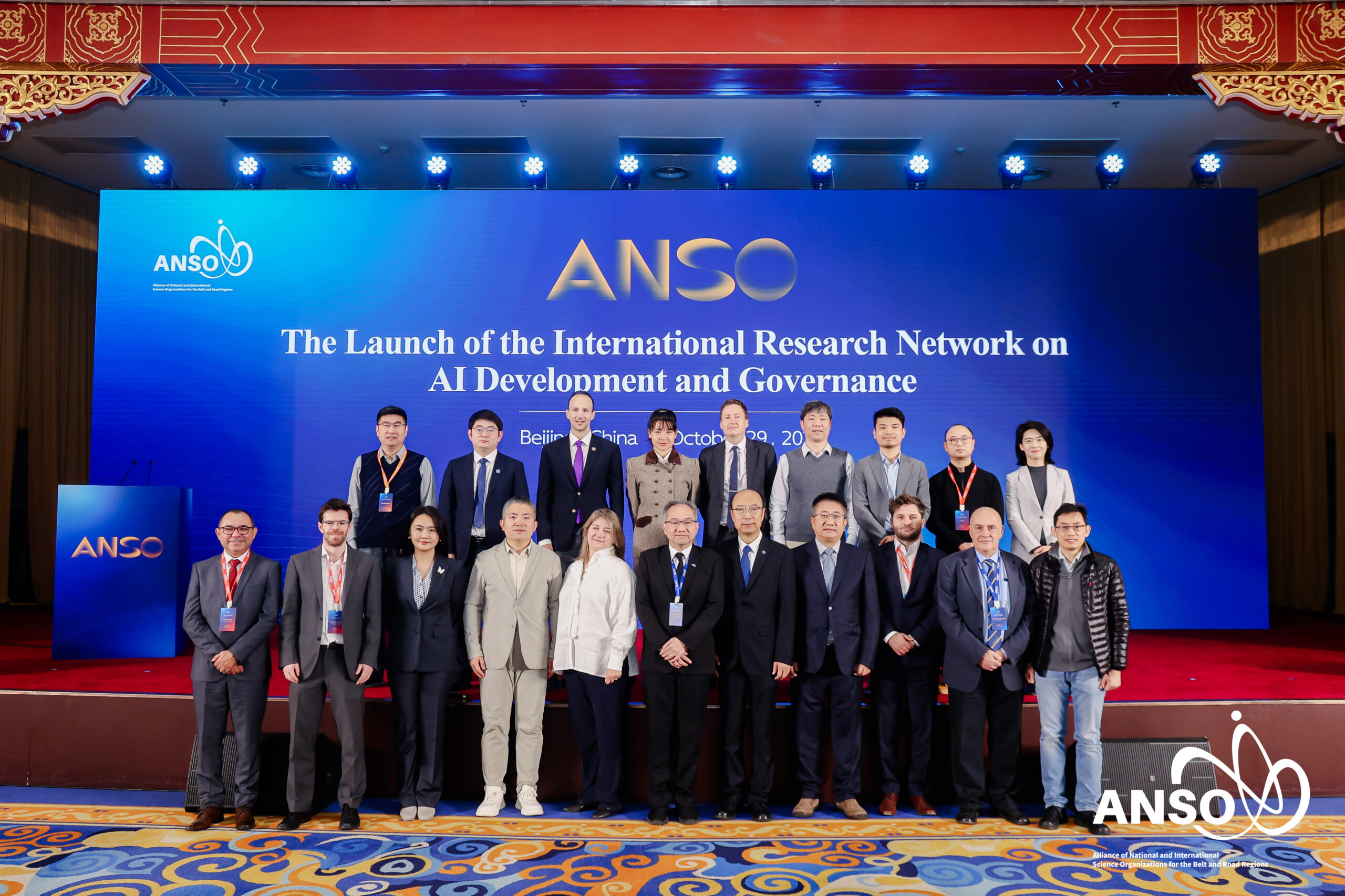 ภาพหมู่ขนาดกว้าง เห็น ผู้บริหารนานาประเทศ ประมาณ 20 คน แถวแรกด้านหน้าเวที แถวสองยืนอยู่บนเวที ที่ปูพรมแดง ด้านหลังเป็น Backdrop มีชื่องาน ANSO ธีมสีน้ำเงิน