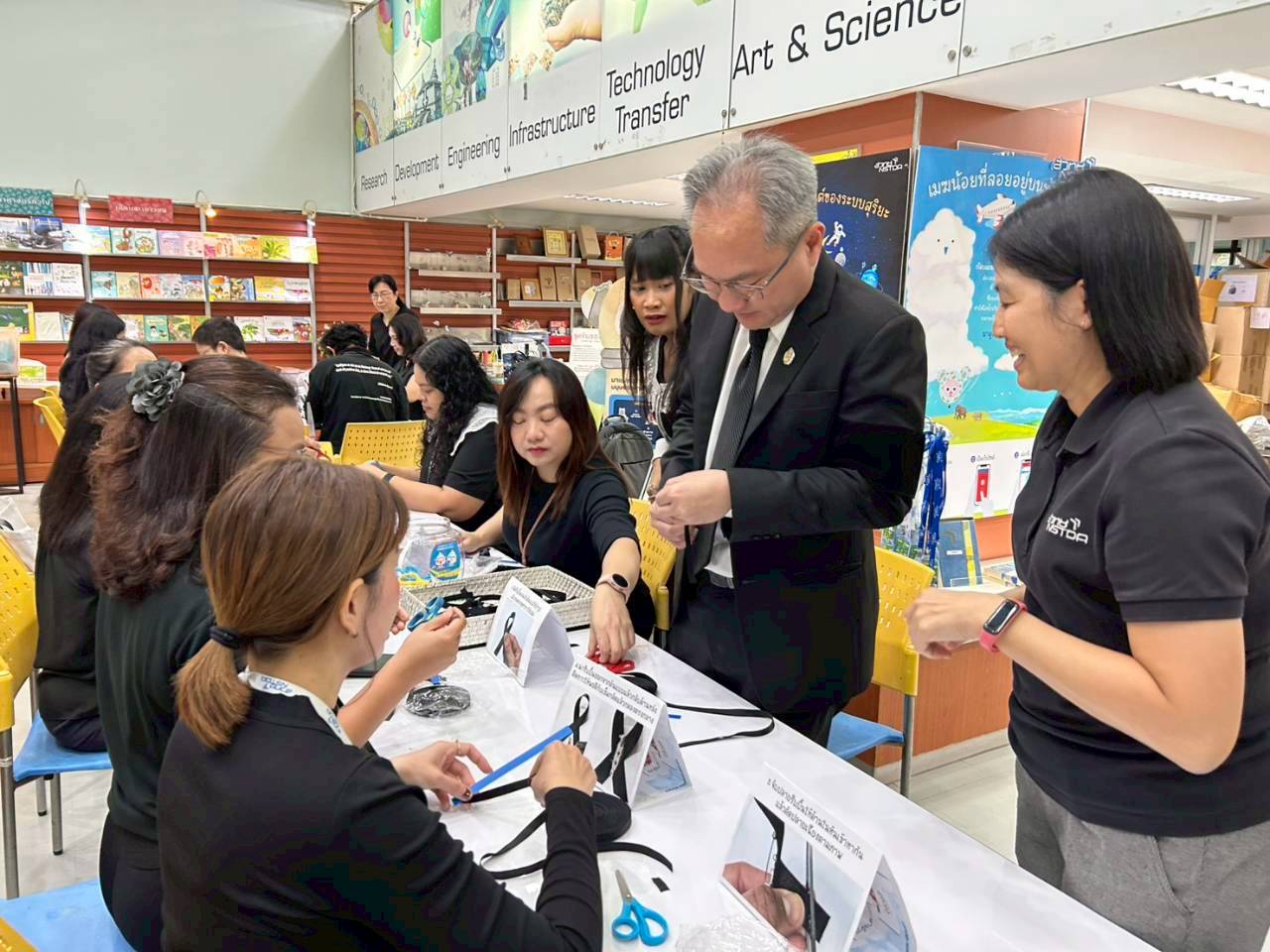 ภาพผู้บริหารและพนักงาน สวทช. ร่วมกันทำริบบิ้นถวายความอาลัย