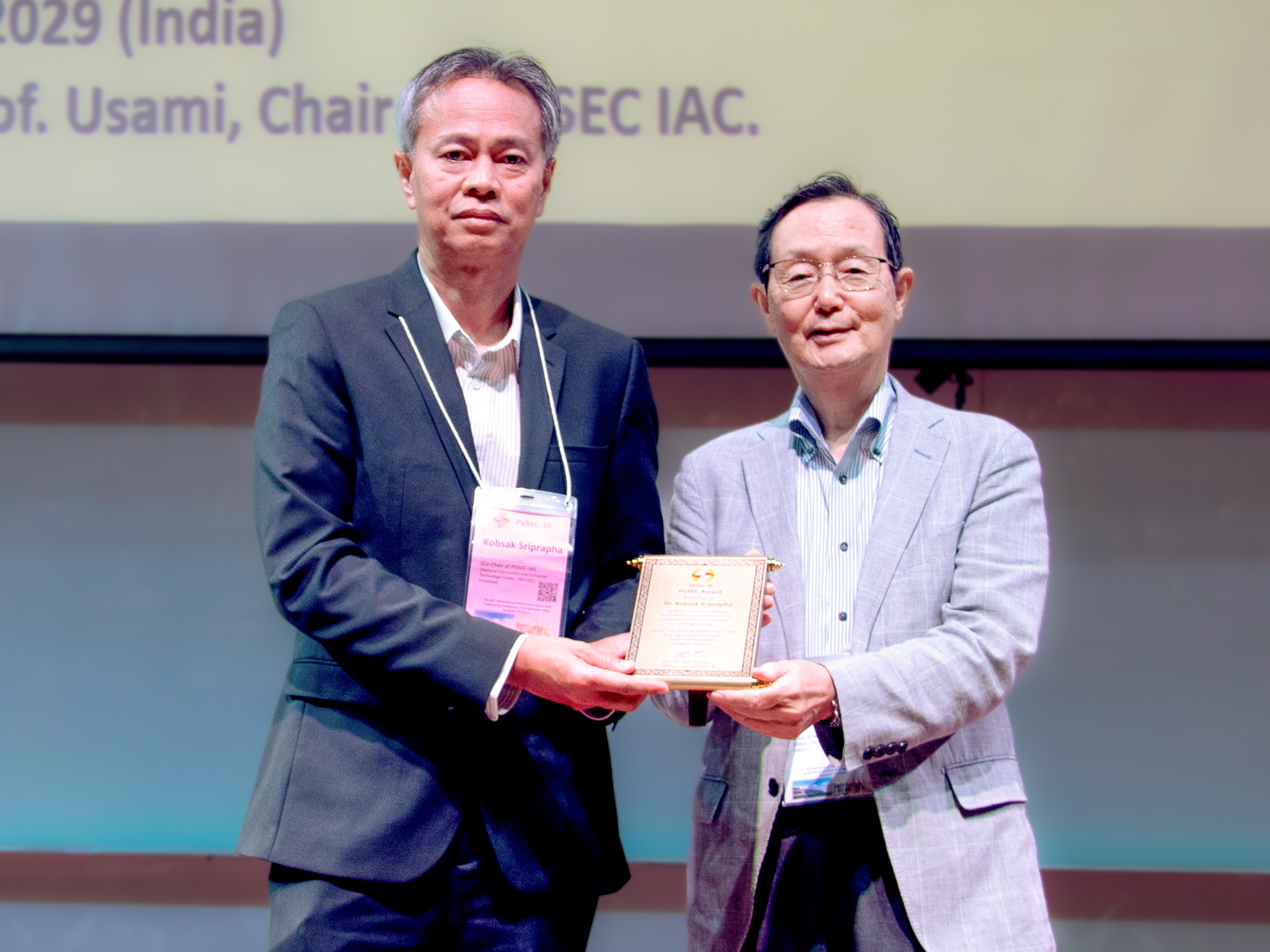 ภาพ ดร.กอบศักดิ์ ศรีประภา จาก NECTEC สวทช. ขณะรับมอบรางวัล PVSEC Award 2025 จากศาสตราจารย์มาโกโตะ โคนากาอิ