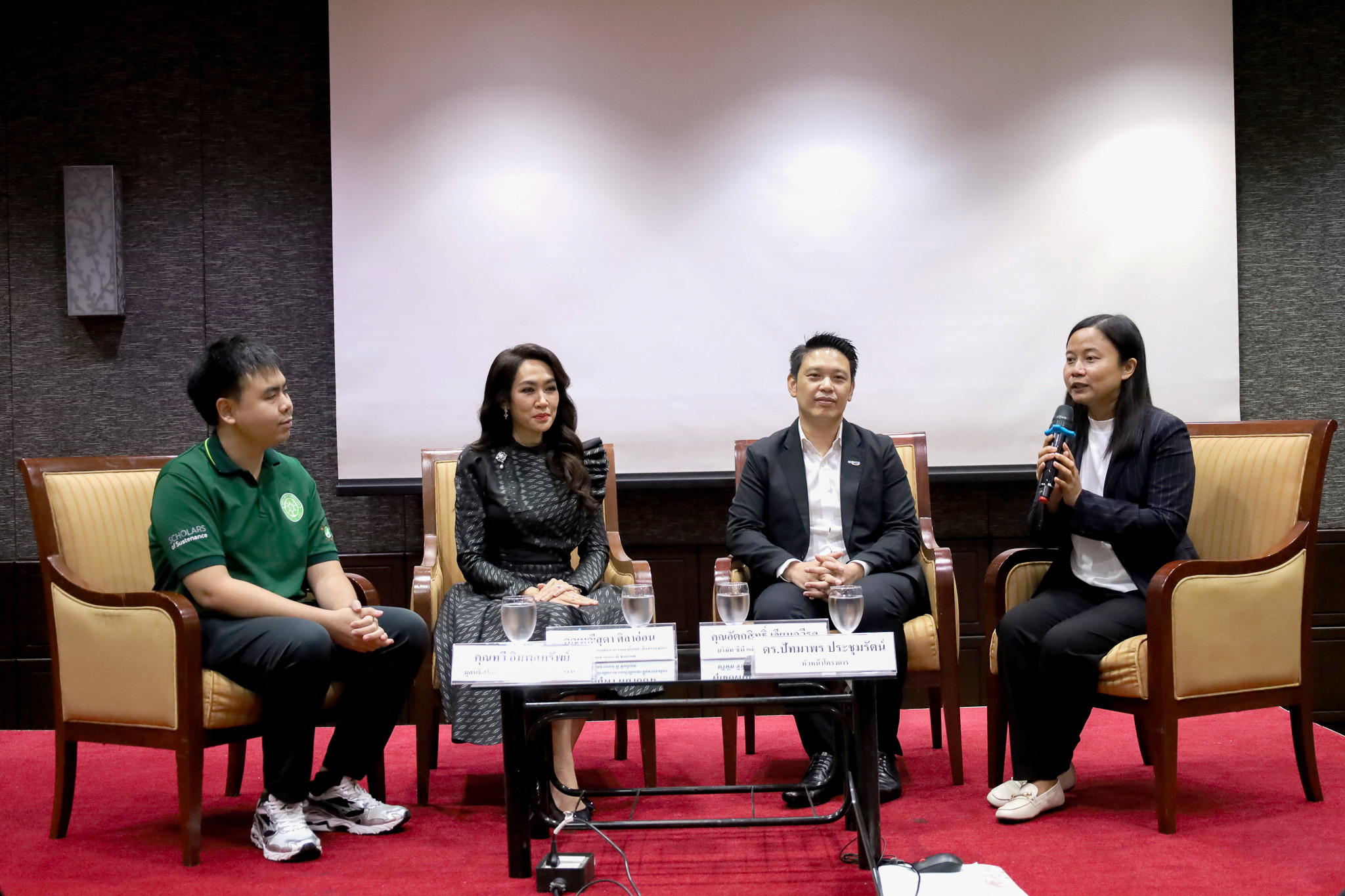 ภาพผู้ร่วมเสวนาสี่คนบนเวทีนั่งสนทนาระหว่างงานประชุม