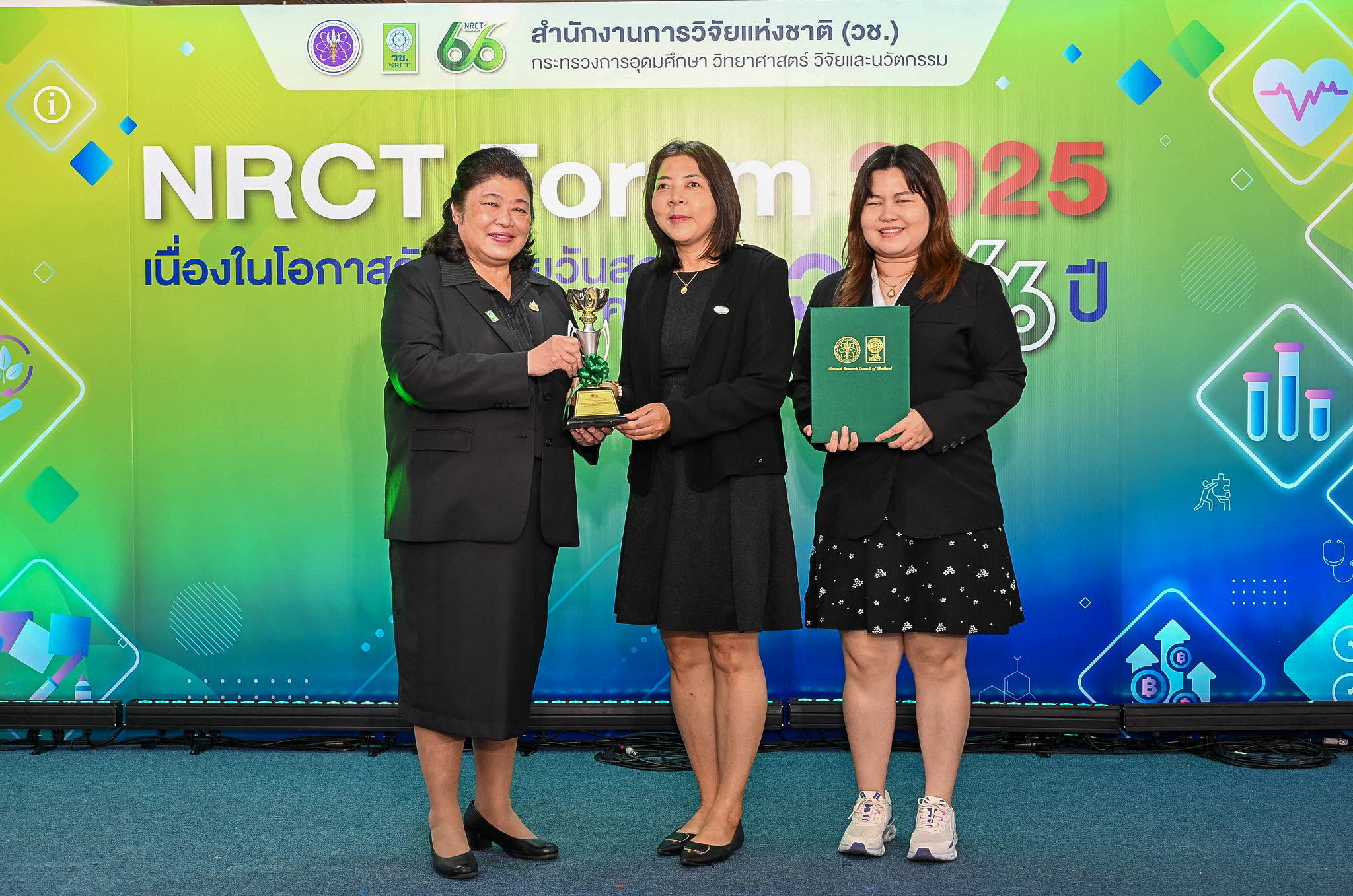 ภาพ ดร.พรรษมณฑ์ ริจิรวนิช นักวิจัย ร่วมถือถ้วยรางวัลและเอกสารรางวัล NRCT AWARD 
