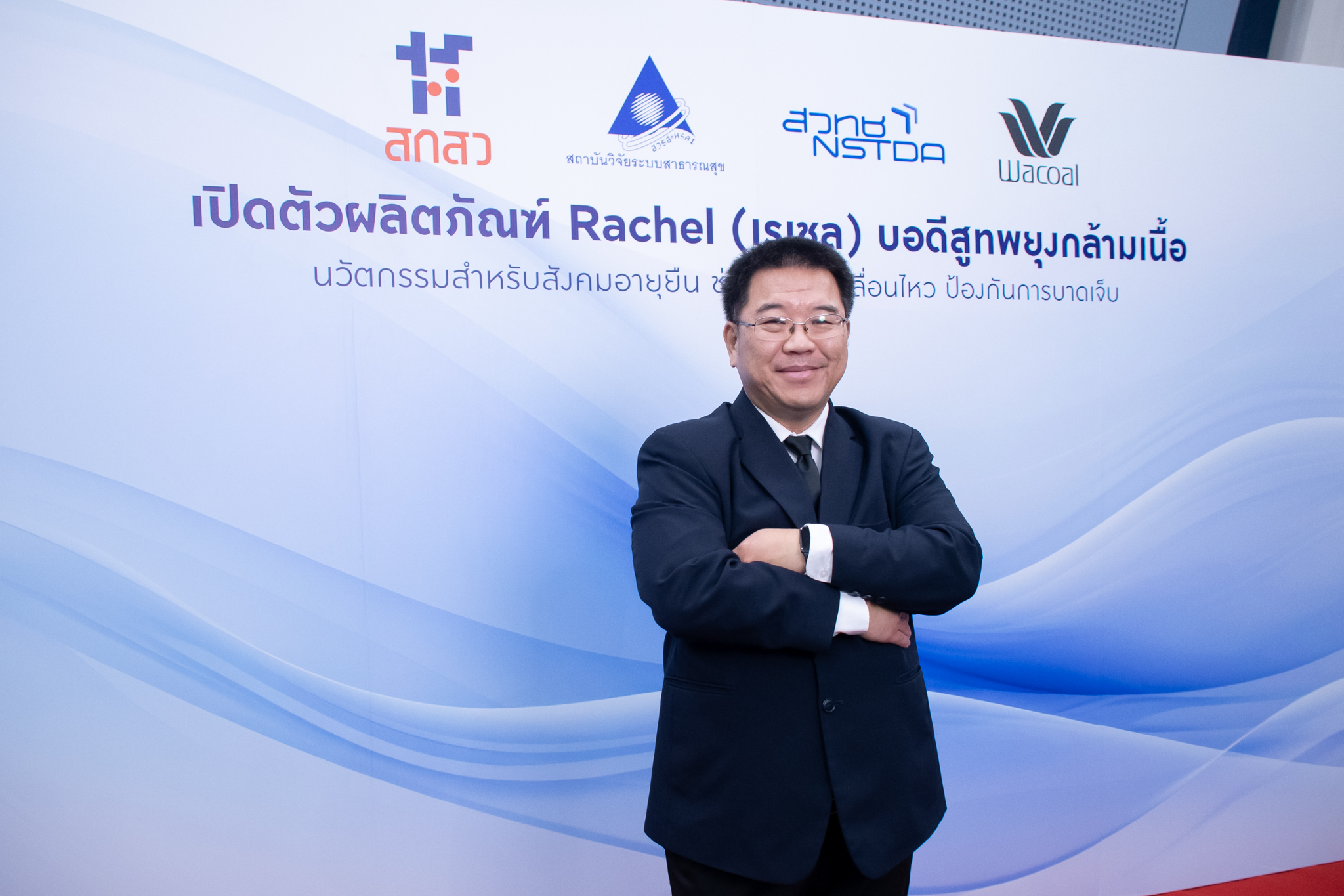 ภาพ รศ.ดร.เติมศักดิ์ ยืนท่ากอด หน้า Backdrop งาน ธีมขาวฟ้า