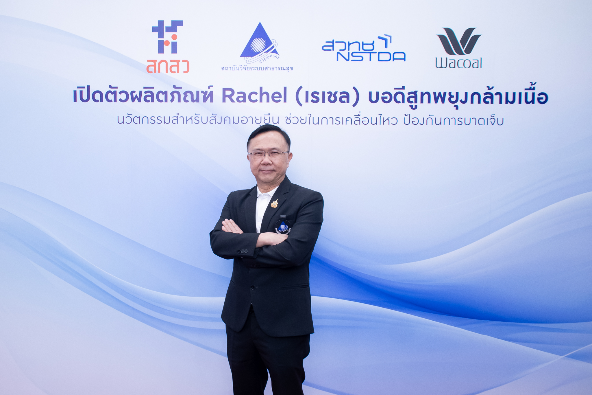 ภาพ นพ.ศุภกิจ ยืนท่ากอด หน้า Backdrop งาน ธีมขาวฟ้า