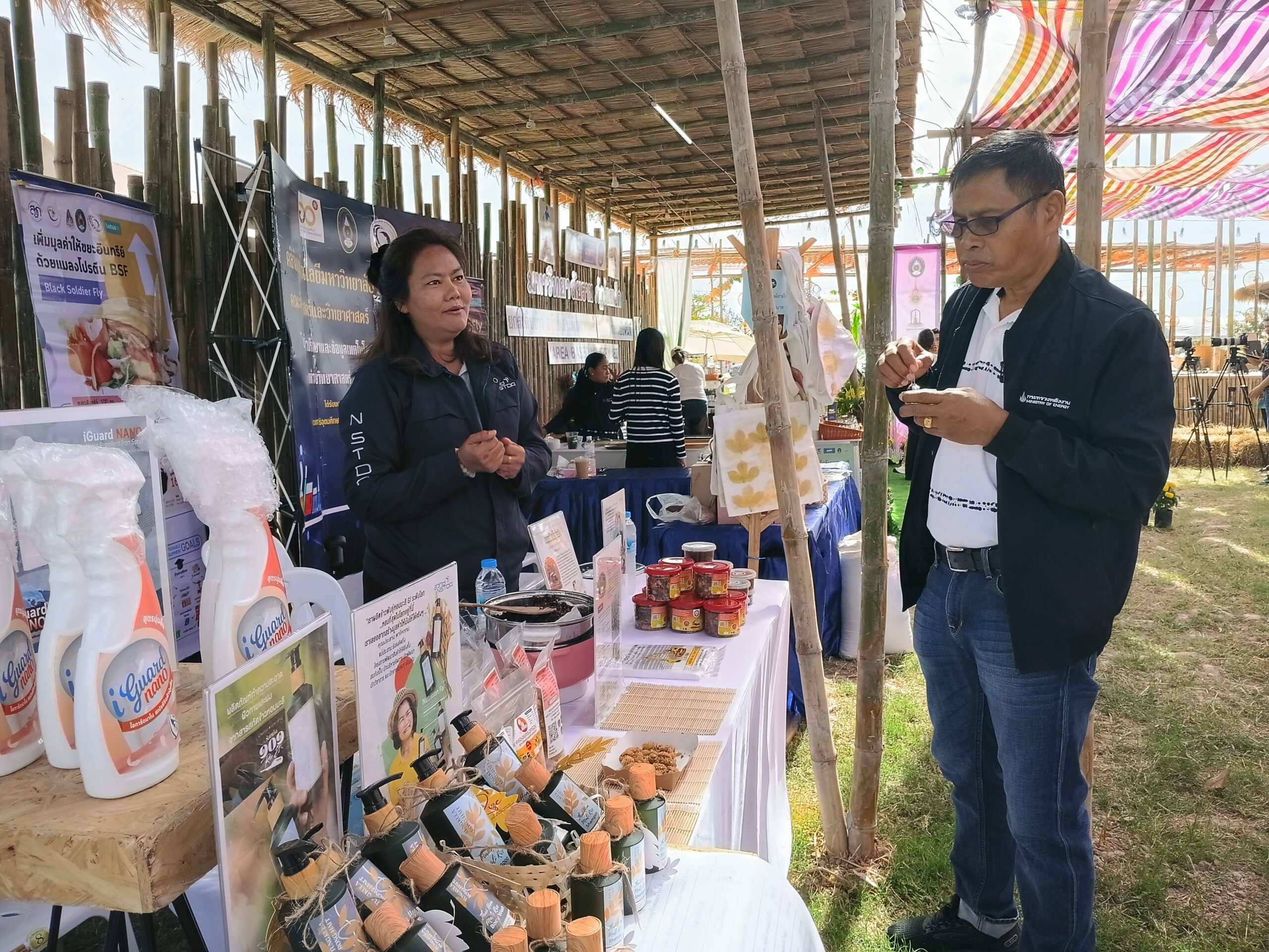 ภาพเจ้าหน้าที่หญิงจาก สวทช. แนะนำผลิตภัณฑ์นวัตกรรมอาหารและสินค้าแปรรูปที่บูธนิทรรศการ ภายในงานเทศกาลข้าวหอมมะลิโลก