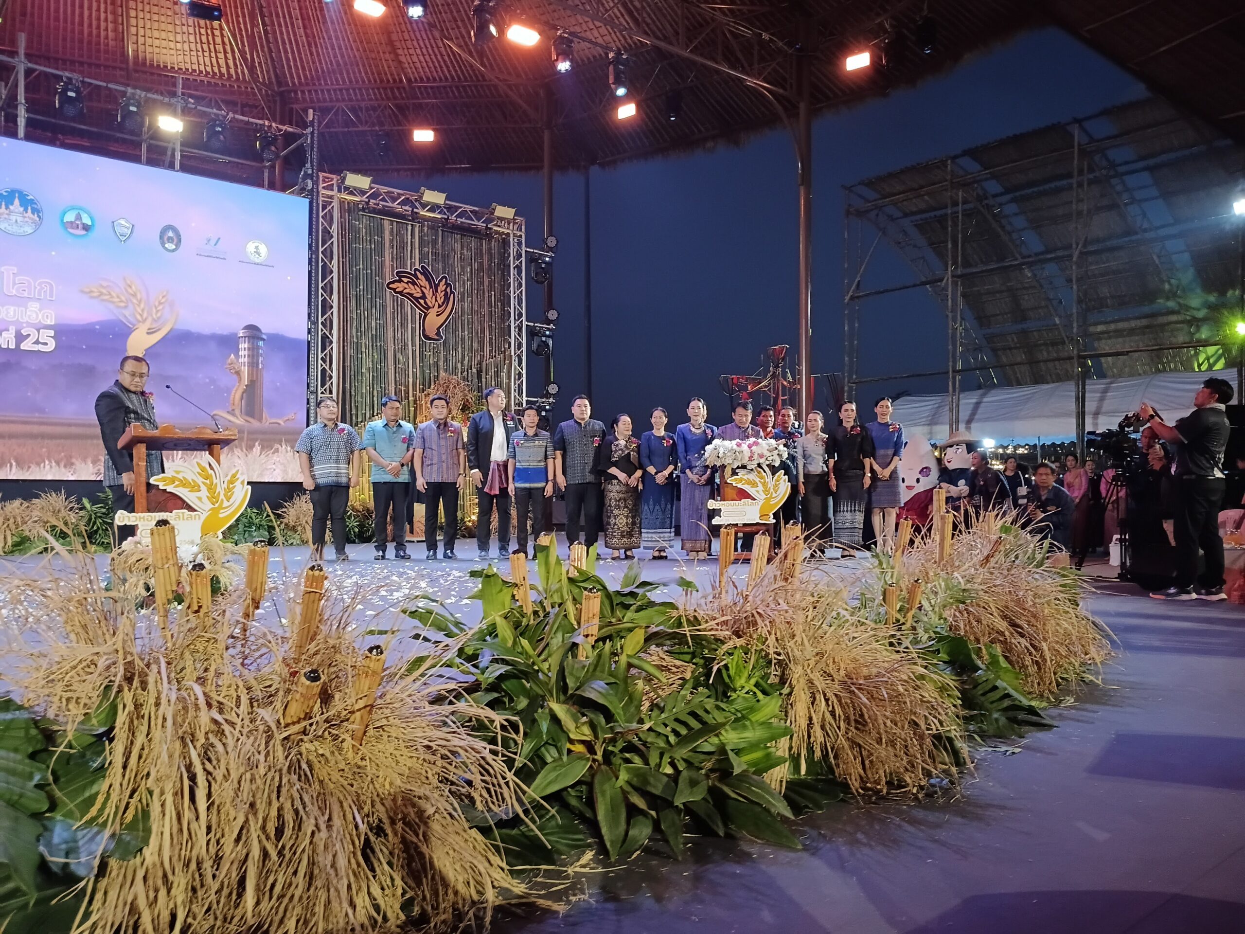 ภาพพิธีเปิดงานเทศกาลข้าวหอมมะลิโลก ครั้งที่ 25 โดยมีผู้บริหารและแขกผู้มีเกียรติร่วมถ่ายภาพหมู่บนเวทีอย่างเป็นทางการ