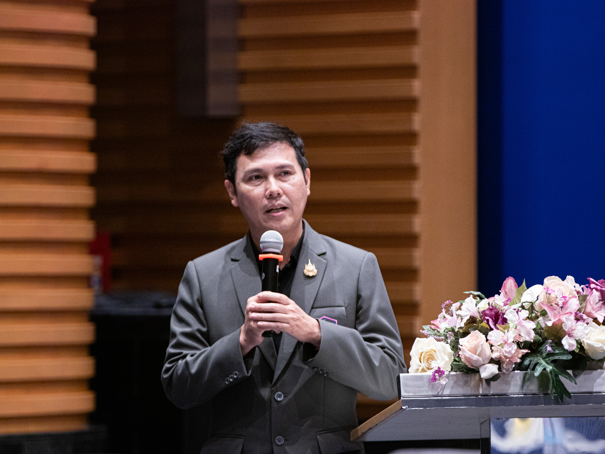 ภาพ: ตัวแทนผู้เข้าอบรมยืนถือไมโครโฟนเพื่อสอบถามและแลกเปลี่ยนเรียนรู้กับวิทยากร