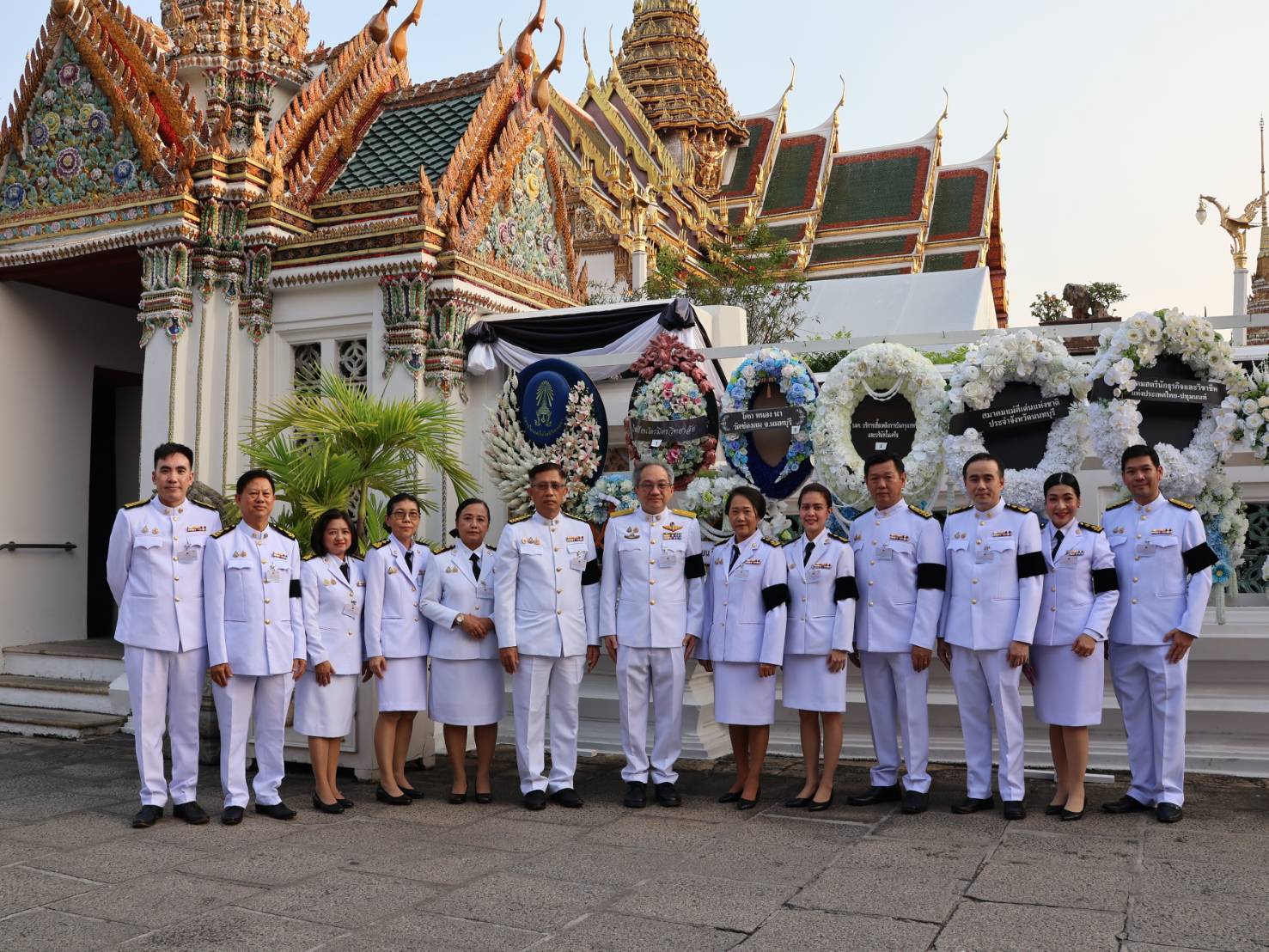 ภาพ คณะผู้บริหารและบุคลากรสำนักงานพัฒนาวิทยาศาสตร์และเทคโนโลยีแห่งชาติ (สวทช.) แต่งกายชุดปกติขาว ยืนแถวเป็นหมู่คณะภายในพระบรมมหาราชวัง ในโอกาสเข้าเฝ้าฯ พระพิธีธรรมสวดพระอภิธรรมพระบรมศพ สมเด็จพระนางเจ้าสิริกิติ์ พระบรมราชินีนาถ พระบรมราชชนนีพันปีหลวง