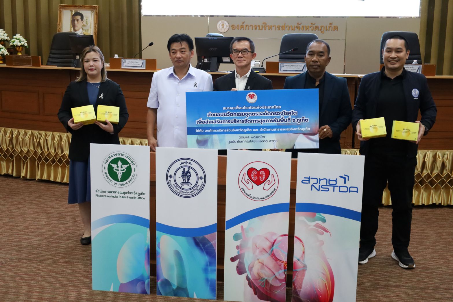 ภาพ: พิธีส่งมอบนวัตกรรมชุดตรวจคัดกรองโรคไต (AL-Strip) อย่างเป็นทางการ โดยมีผู้บริหารจาก สวทช., อบจ.ภูเก็ต, สสจ.ภูเก็ต และสมาคมเพื่อนโรคไตแห่งประเทศไทย ร่วมถือป้ายสัญลักษณ์และกล่องชุดตรวจ