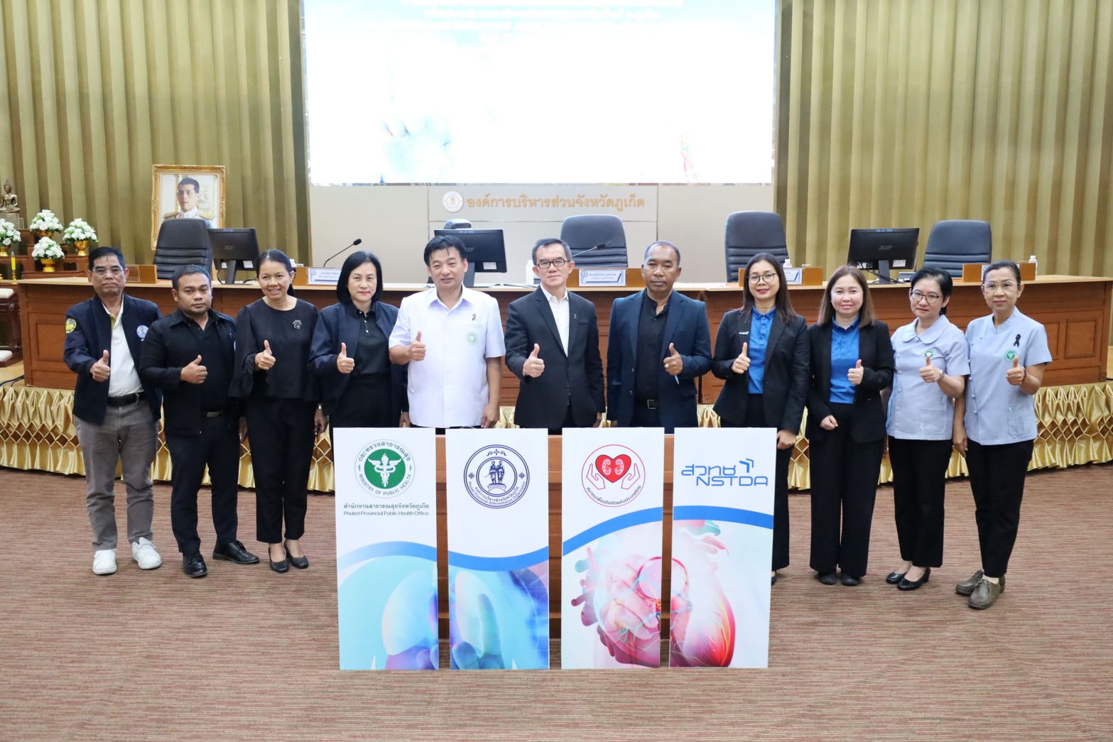 ภาพ: คณะผู้บริหารและเจ้าหน้าที่จาก 4 หน่วยงานพันธมิตร (สวทช., อบจ.ภูเก็ต, สสจ.ภูเก็ต, สมาคมเพื่อนโรคไตฯ) ถ่ายภาพร่วมกันพร้อมทำท่ากดไลก์ แสดงความพร้อมในการขับเคลื่อนโครงการ