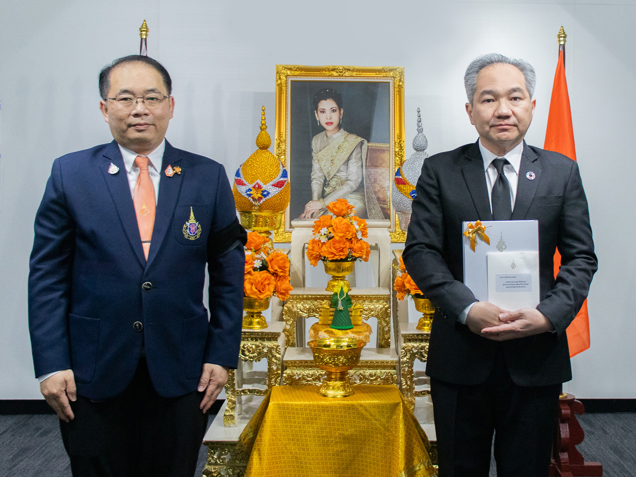 ภาพนายปิยพล  และ  ศาสตราจารย์ ดร.ชูกิจ ยนถือ บัตรอวยพร (ส.ค.ส.) พระราชทาน ต่อหน้าพระบรมฉายาลักษณ์ ศาสตราจารย์ ดร.สมเด็จพระเจ้าน้องนางเธอ เจ้าฟ้าจุฬาภรณวลัยลักษณ์ อัครราชกุมารี กรมพระศรีสวางควัฒน วรขัตติยราชนารี