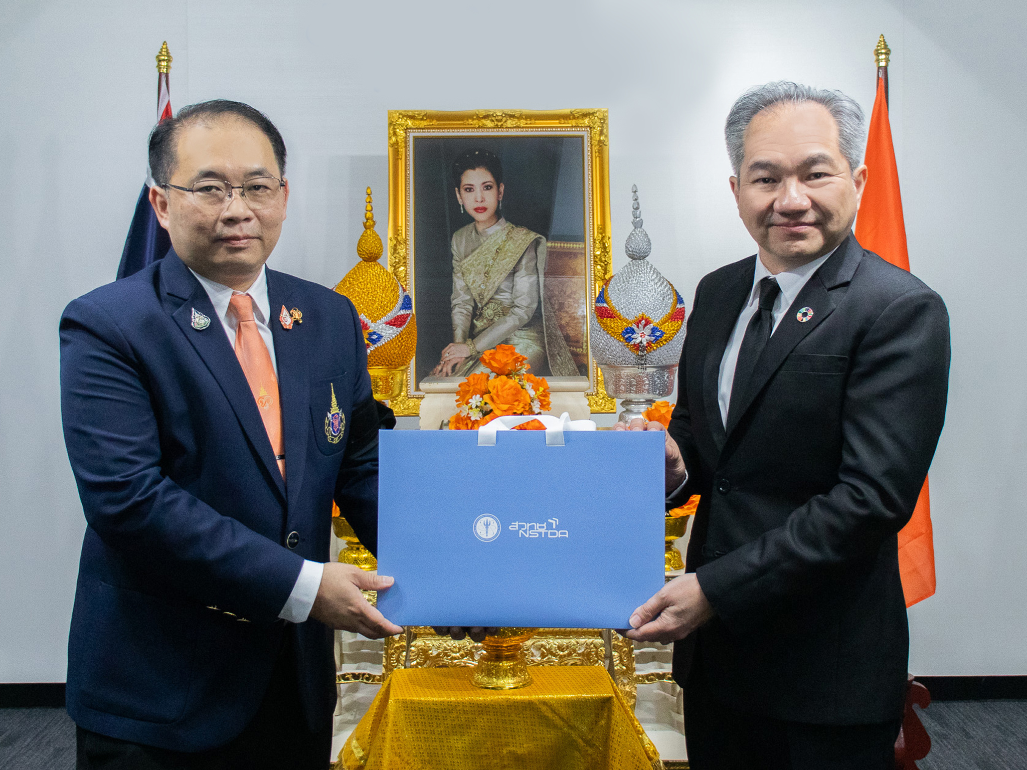 ภาพศาสตราจารย์ ดร.ชูกิจ นายปิยพล มอบของที่ระลึกแก่ นายปิยพล ต่อหน้าพระบรมฉายาลักษณ์ ศาสตราจารย์ ดร.สมเด็จพระเจ้าน้องนางเธอ เจ้าฟ้าจุฬาภรณวลัยลักษณ์ อัครราชกุมารี กรมพระศรีสวางควัฒน วรขัตติยราชนารี