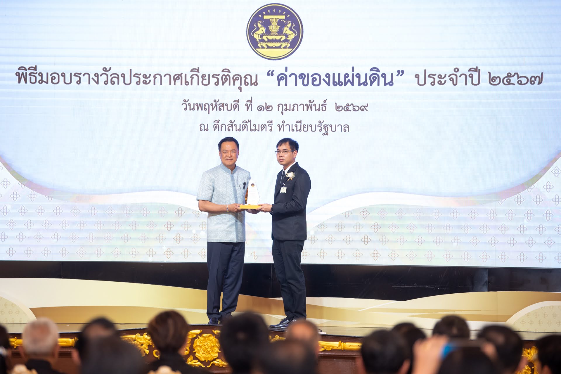 ภาพดร.วสันต์ ภัททรอธิคม ผู้ช่วยผู้อำนวยการ สวทช. ขึ้นรับมอบรางวัลโล่ประกาศเกียรติคุณ ด้านการพัฒนาสังคมและส่งเสริมคุณภาพชีวิต จากนายอนุทิน ชาญวีรกูล นายกรัฐมนตรี ประเภทโครงการ จากผลงานการพัฒนา Traffy Fondue แพลตฟอร์มบริหารจัดการปัญหาเมือง