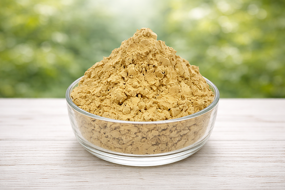 ผลิตภัณฑ์ EM รูปแบบผงในถ้วยแก้ว ผงมีลักษณะเป็นสีเหลืองอมส้ม