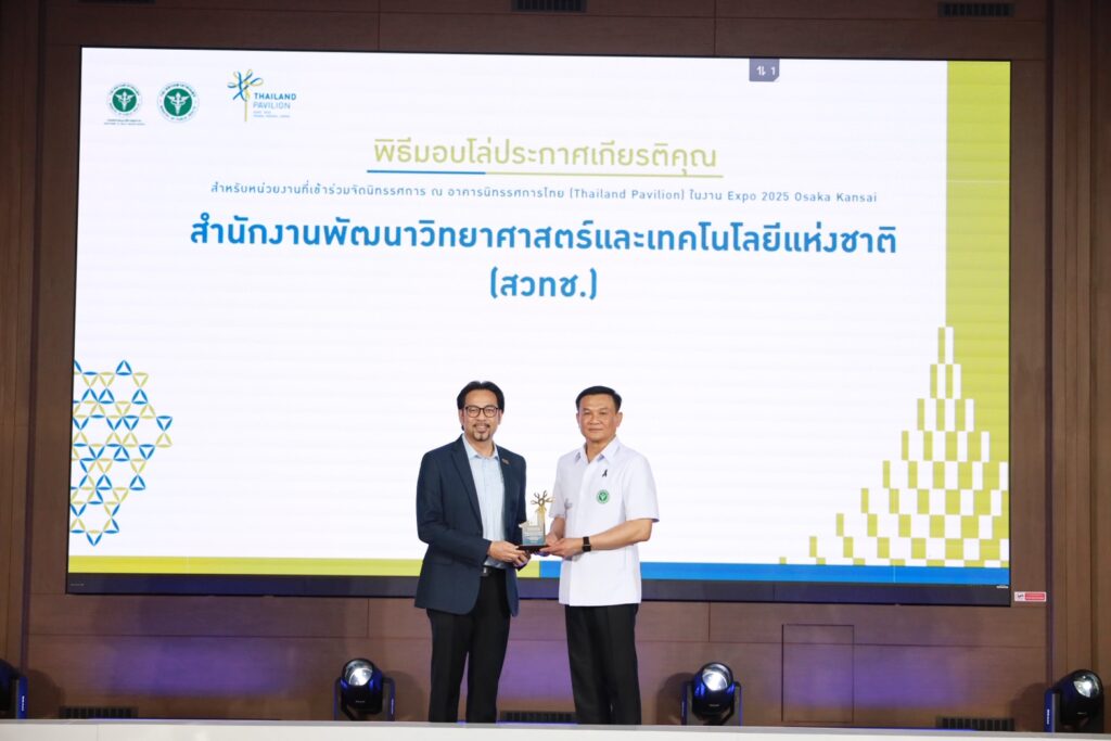 ภาพ: ดร.วรวรงค์ รักเรืองเดช เป็นผู้แทน สวทช. รับมอบโล่ประกาศเกียรติคุณ บนเวทีที่มีหน้าจอแสดงชื่อสำนักงานพัฒนาวิทยาศาสตร์และเทคโนโลยีแห่งชาติ