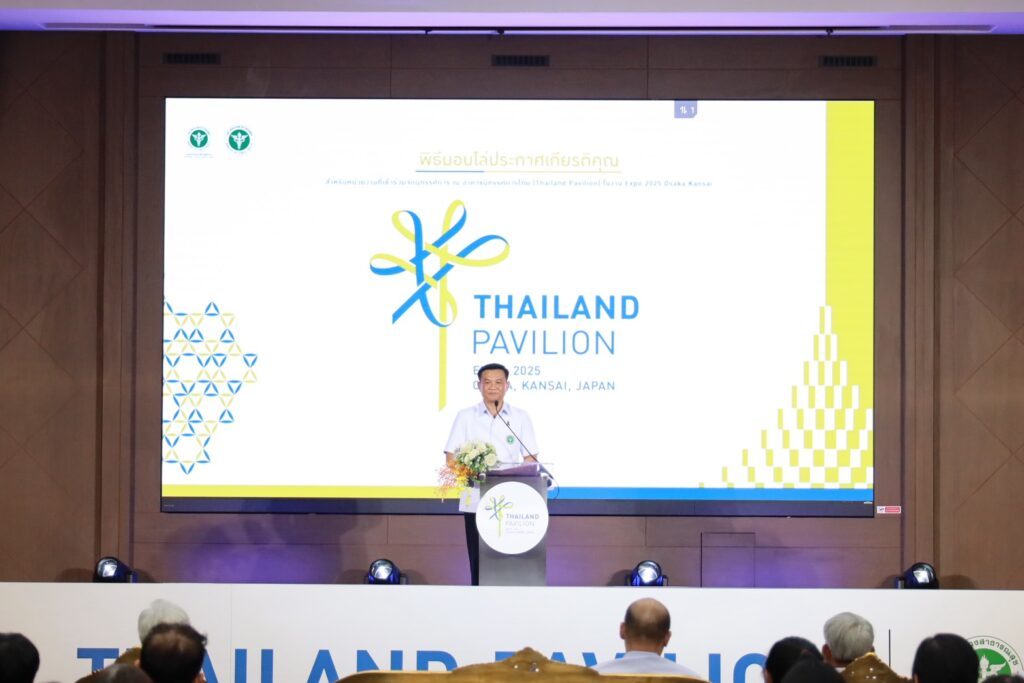 ภาพ: นายแพทย์สุระ วิเศษศักดิ์ ที่ปรึกษาอาคารนิทรรศการไทย กล่าวรายงานและเปิดพิธีมอบโล่ประกาศเกียรติคุณ ณ โพเดียม