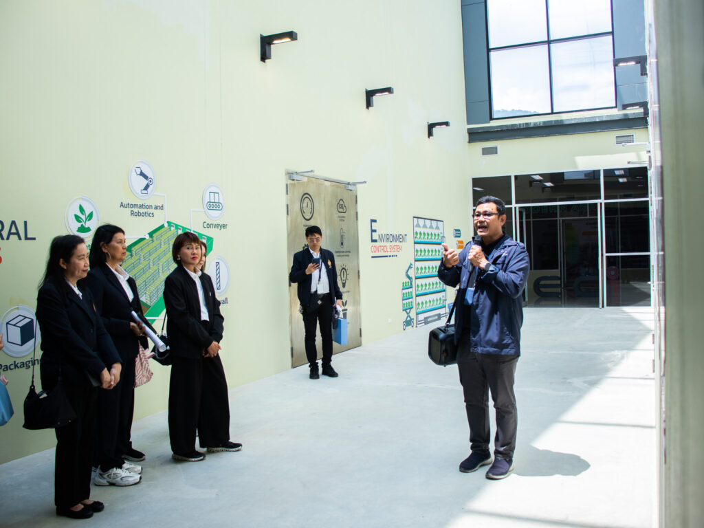 ภาพ: การบรรยายให้ความรู้แก่คณะ นงส. รุ่นที่ 13 บริเวณพื้นที่จัดแสดงเทคโนโลยีโรงเรือนปลูกพืชอัจฉริยะ (Smart Greenhouse) ภายใน EECi