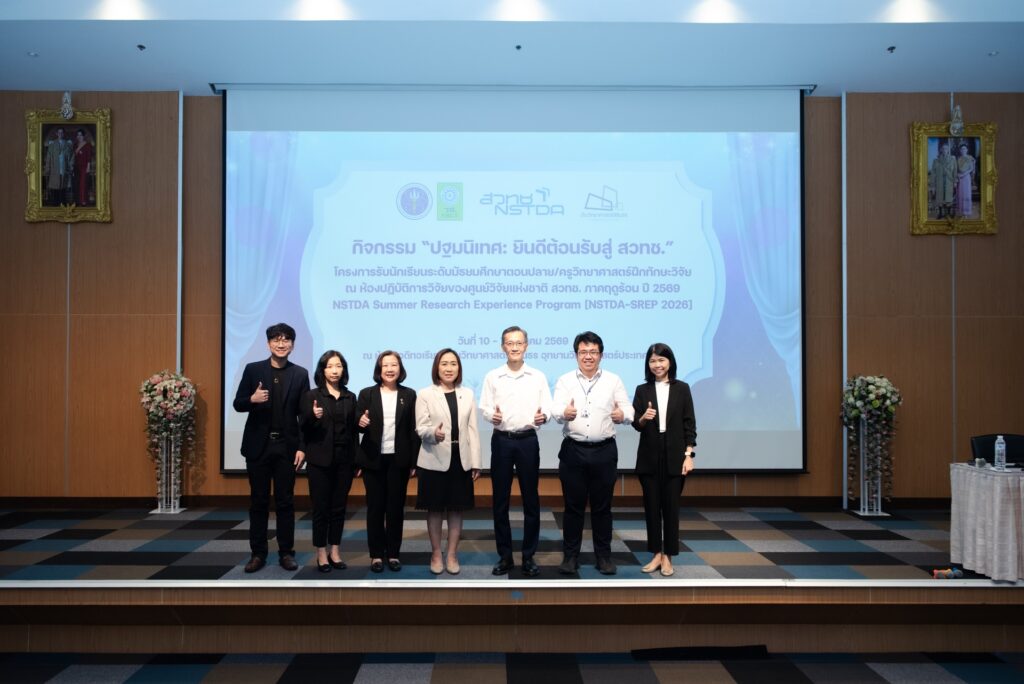 คณะผู้บริหาร สวทช. ผู้แทนจากหน่วยงานพันธมิตร และวิทยากร ถ่ายภาพร่วมกันบนเวทีในงานปฐมนิเทศโครงการฝึกทักษะวิจัยภาคฤดูร้อน ปี 2569