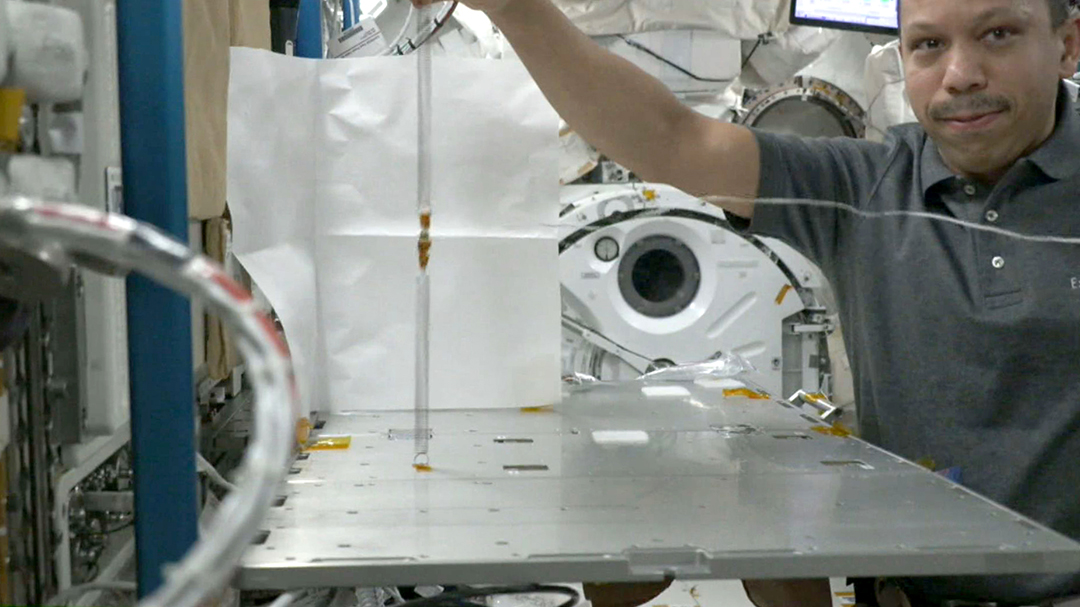 นักบินอวกาศกำลังทดลองการสั่นของสปริงและเชือกในสภาวะไร้น้ำหนัก