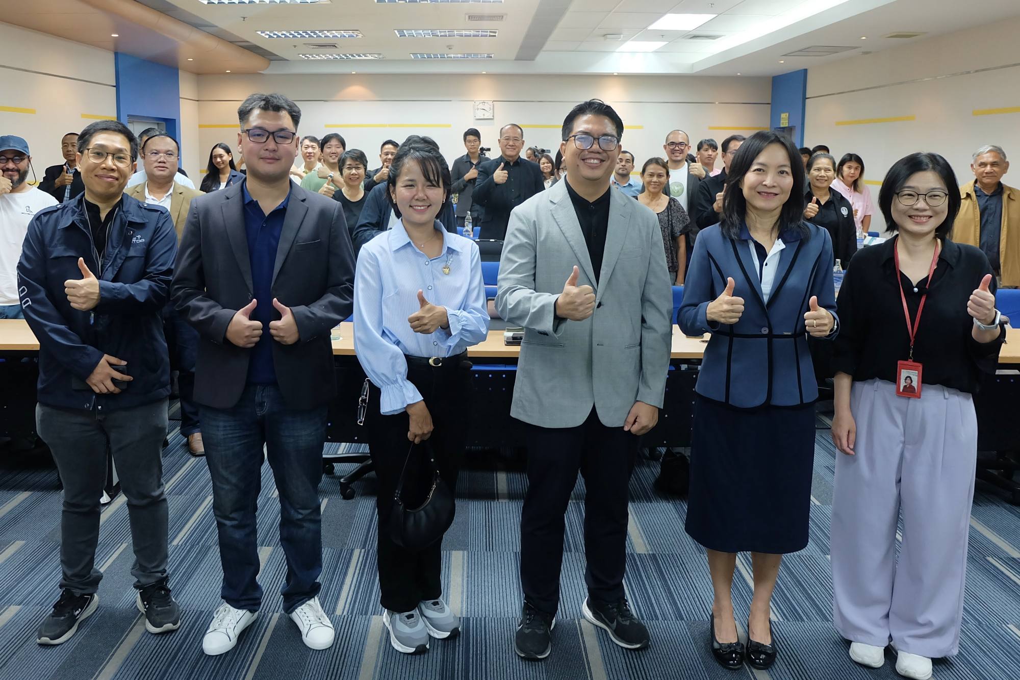 ภาพหมู่ วิทยากรและผู้เข้าร่วมสัมมนา กำลังยืนกดไลท์ด้วยมือซ้าย