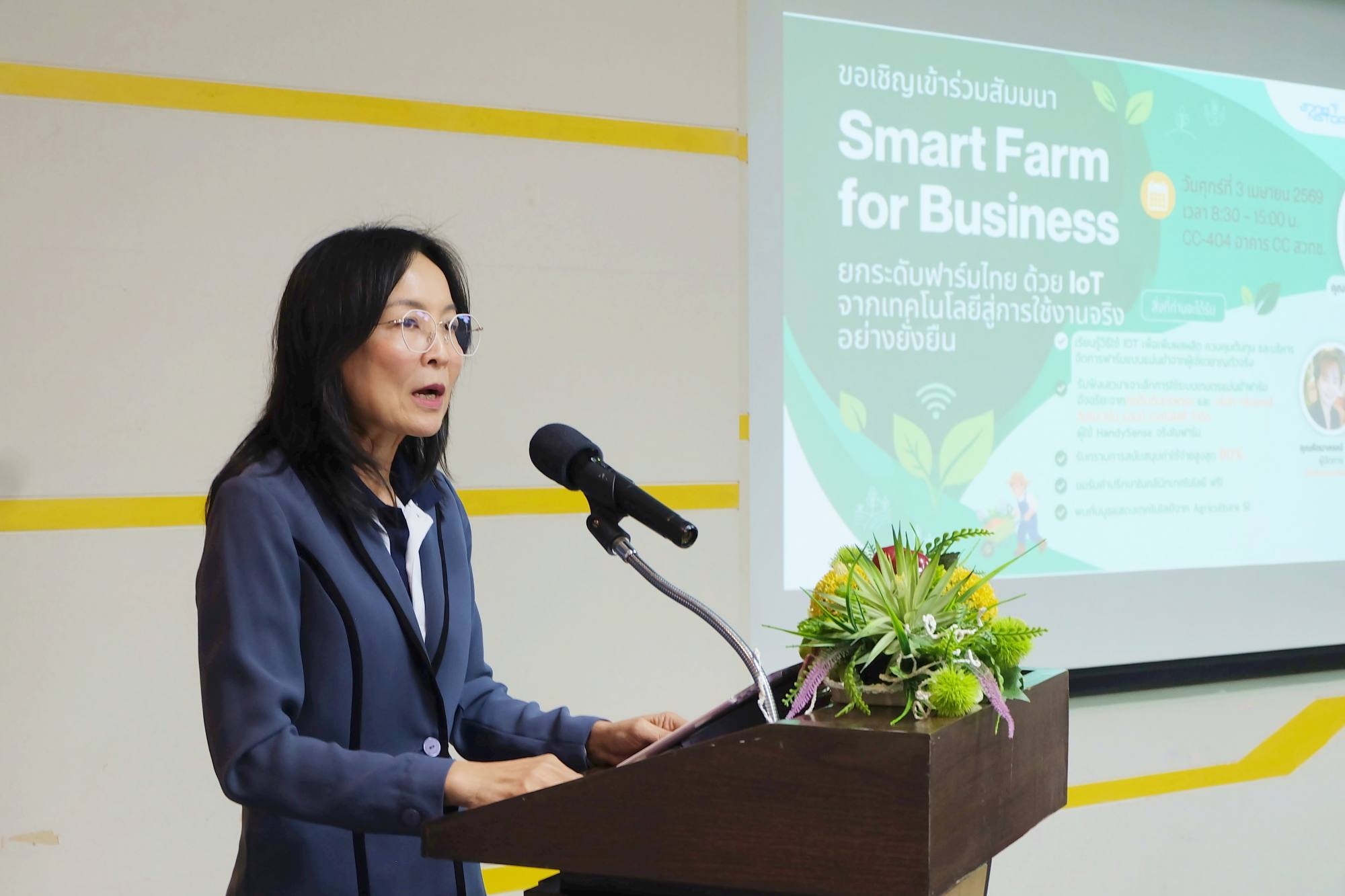 ภาพ ดร. นันทิยา กำลังยืนกล่าว หน้าโพเดียม และด้านข้างเป็น จอ Backdrop งาน