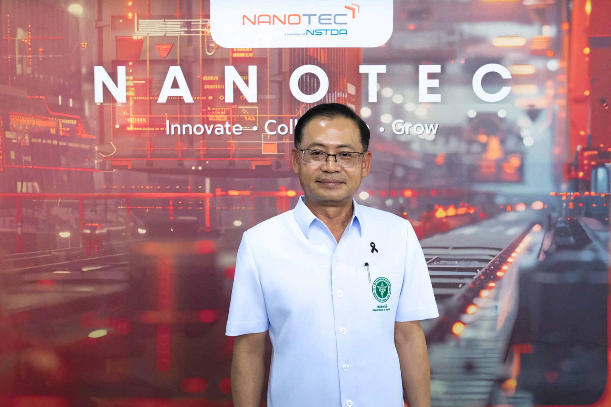 ภาพ นายแพทย์นเรศฤทธิ์ ยืนหน้า Backdrop นาโนเทค