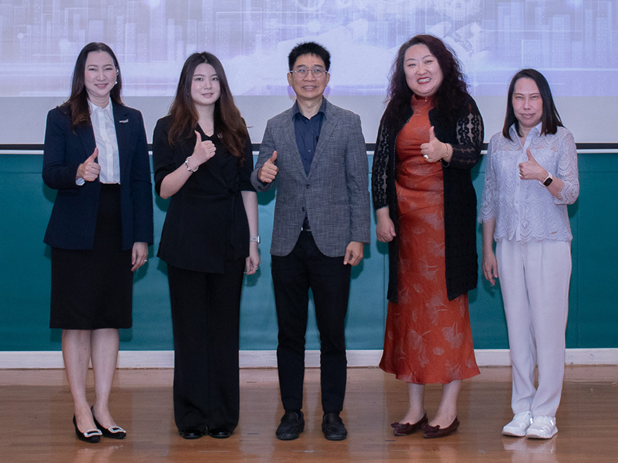 ภาพ นางศันสนีย์ ดร.วสันต์  ดร.กัว และ ดร.กอบกุล ถ่ายภาพบนเวที โดยทำท่ากดไลท์มือขวา