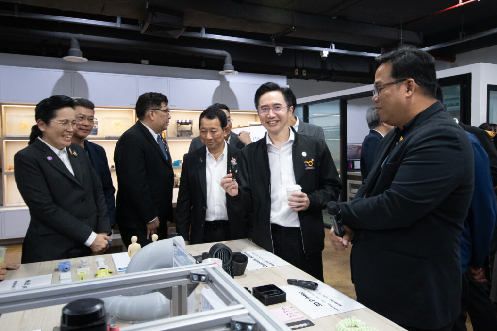 ศ. ดร.ยศชนัน วงศ์สวัสดิ์ ถือโมเดล 3 มิติขนาดเล็ก ขณะเยี่ยมชมผลงานวิจัยด้านเทคโนโลยี 3D Printing และวัสดุขั้นสูงของ สวทช.