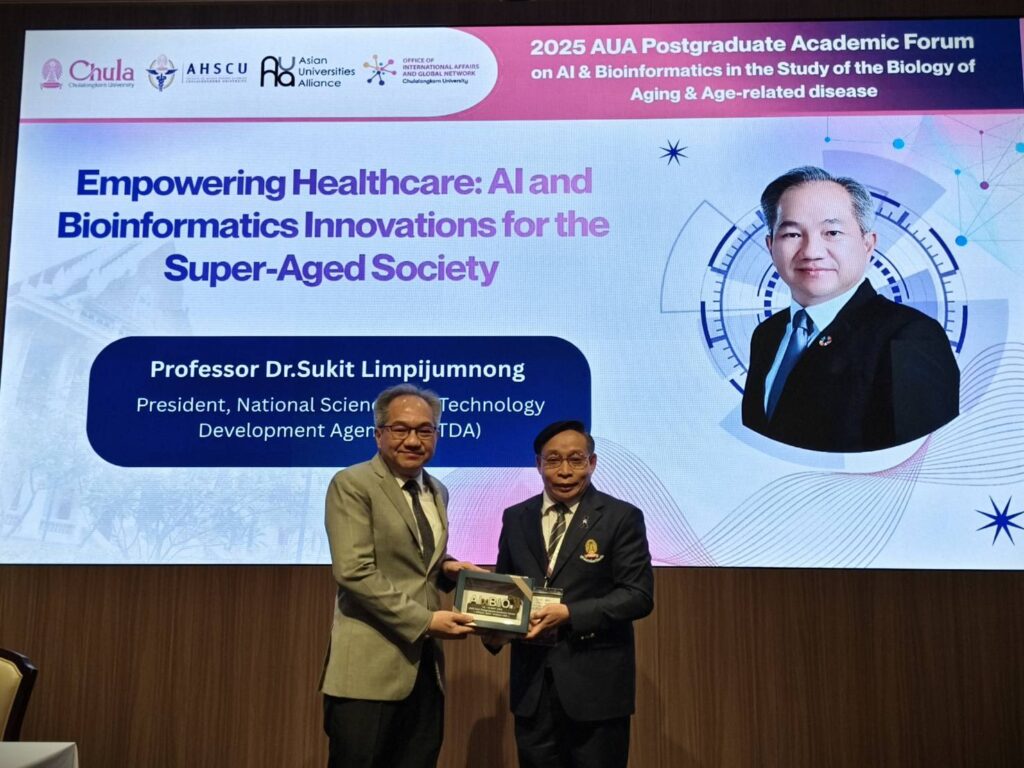 ภาพ าสตราจารย์ ดร.ชูกิจ ลิมปิจำนงค์ ผู้อำนวยการ สวทช. รับมอบของที่ระลึกหลังการบรรยายพิเศษในงาน AUA Postgraduate Academic Forum