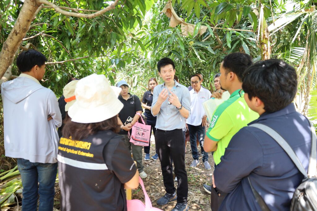 ภาพ ดร.อลงกรณ์ อธิบายให้ผู้ร่วมฟัง ในสวนมะม่วง