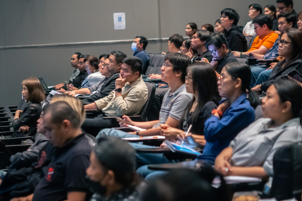 ภาพบรรยากาศด้านข้างของผู้ร่วมงานสัมมนา AI & Human Synergy 2026 กำลังนั่งฟังบรรยาย