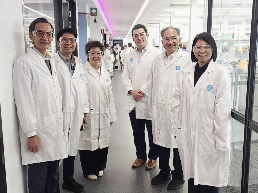 คณะผู้บริหารและนักวิจัย สวทช. ถ่ายภาพร่วมกับเจ้าหน้าที่ CSIRO ในอาคารปฏิบัติการ
