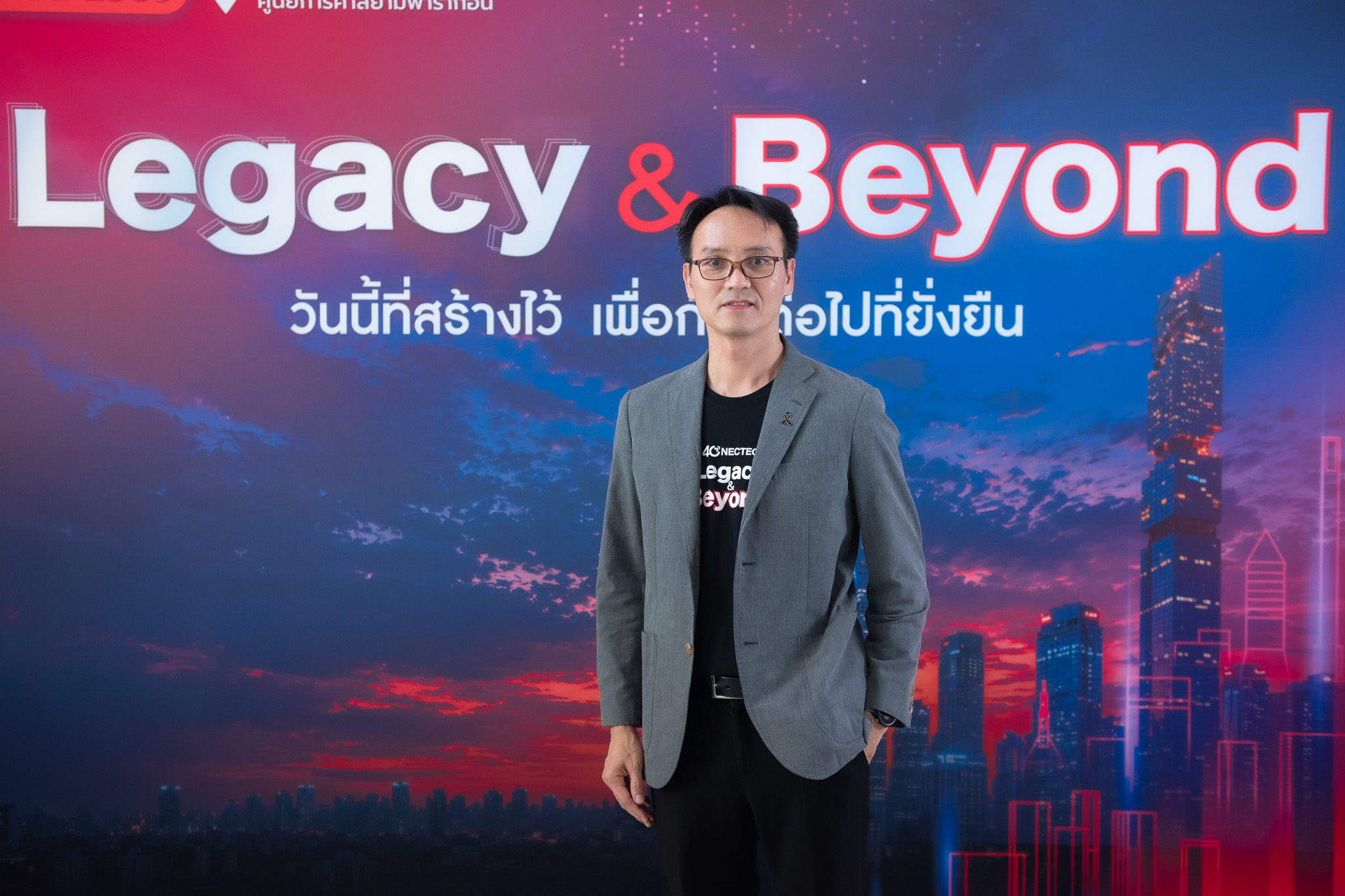 ภาพ ดร.ชัย วุฒิวิวัฒน์ชัย ผู้อำนวยการเนคเทค สวทช. หน้า Backdrop NECTEC 40 Years – Legacy & Beyond
