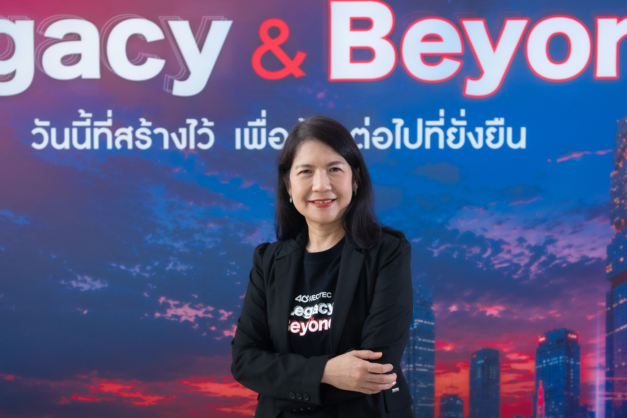 ภาพ ดร.พนิตา พงษ์ไพบูลย์ รองผู้อำนวยการเนคเทค สวทช. ยืนหน้า Backdrop NECTEC 40 Years – Legacy & Beyond
