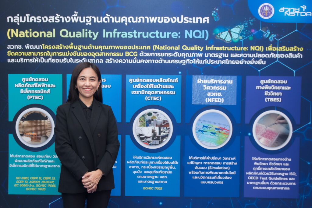 นางสาวิตรี กองเกียรติวานิช ถ่ายภาพหน้าบอร์ดข้อมูล NQI ของ สวทช. สะท้อนบทบาทการทดสอบผลิตภัณฑ์เครื่องใช้ในบ้านและเซรามิกอุตสาหกรรม