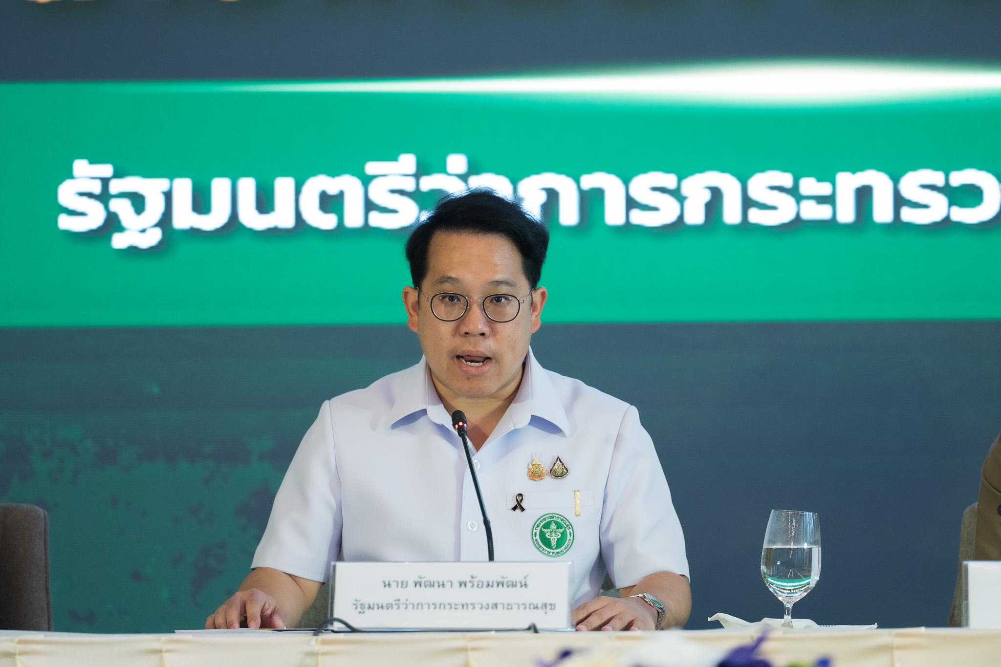 ภาพ นายพัฒนา พร้อมพัฒน์ รัฐมนตรีว่าการกระทรวงสาธารณสุข กำลังกล่าว ในพิธีลงนามความร่วมมือการใช้ Traffy Fondue เพื่อเฝ้าระวังโรคในเรือนจำ