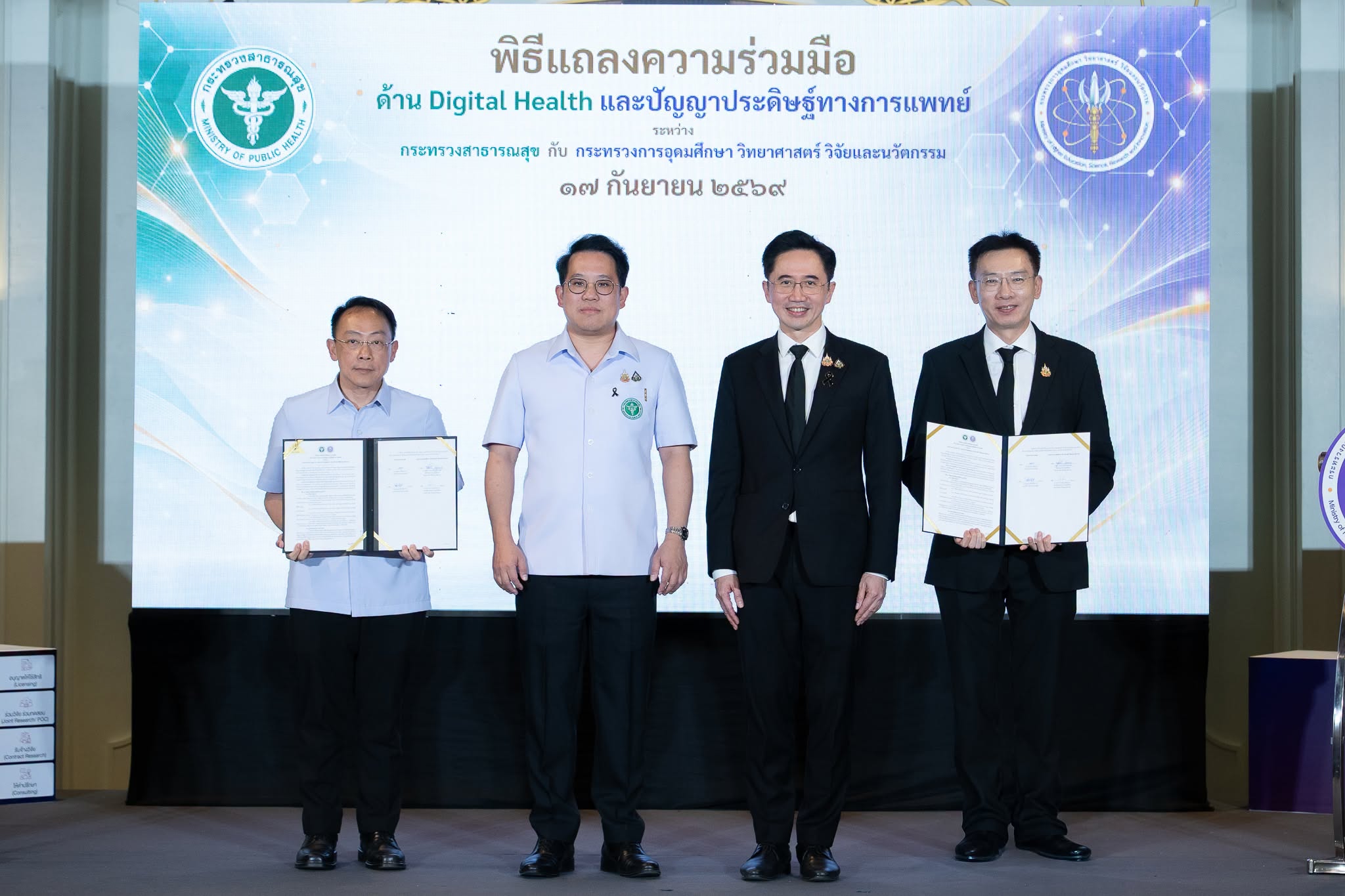 ภาพถ่ายรูปหมู่บนเวที โดยผู้บริหารทั้ง 2 หน่วยงาน โดยมี ศาสตราจารย์ ดร.ยศชนัน วงศ์สวัสดิ์ รองนายกรัฐมนตรีและรัฐมนตรีว่าการกระทรวงการอุดมศึกษา วิทยาศาสตร์ วิจัยและนวัตกรรม เป็นสักขีพยาน